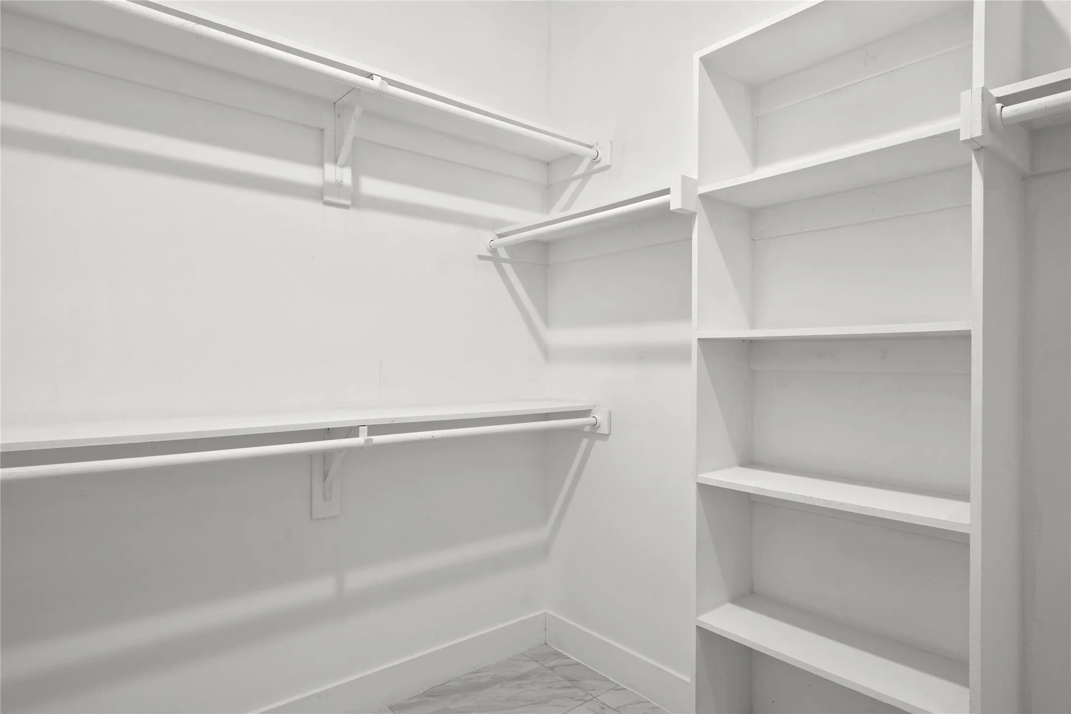Spacious closet with light marble finish floors