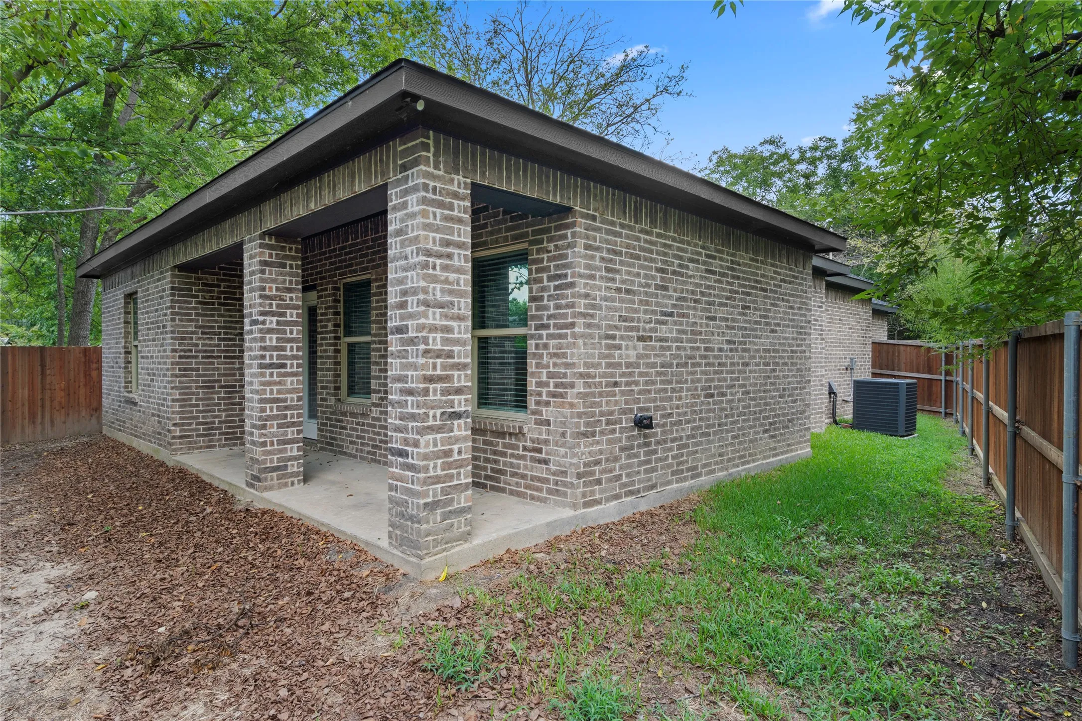 View of home's exterior featuring a fenced backyard and brick siding