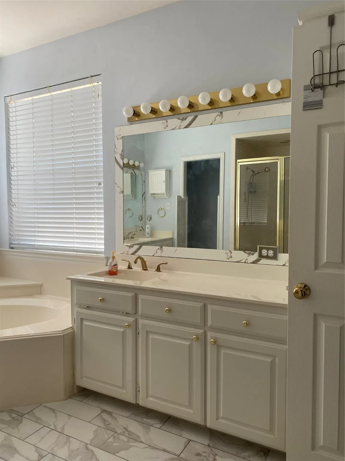 Bathroom with a shower stall, vanity, a garden tub, and light marble finish floors