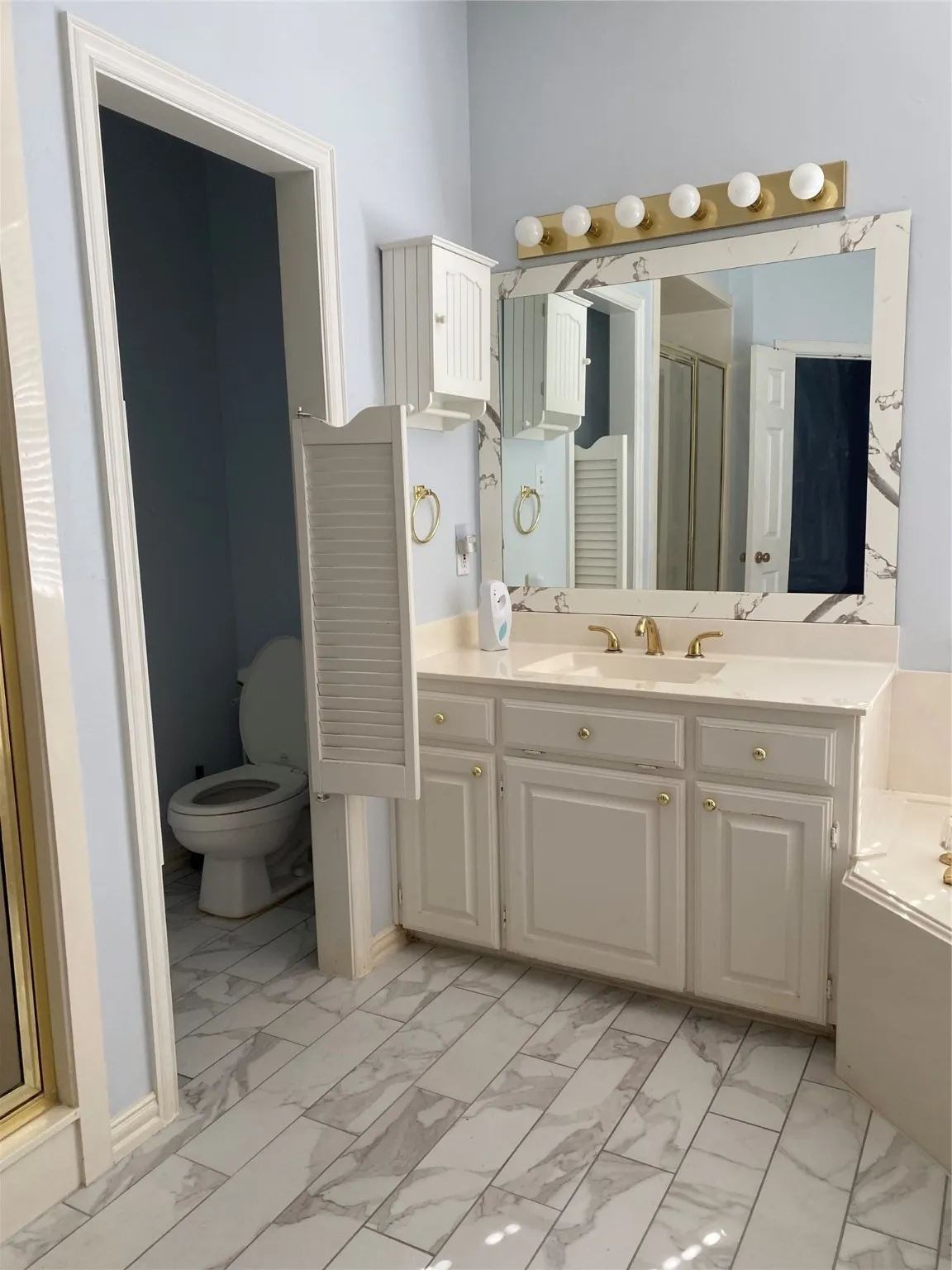 Full bath with light marble finish flooring, vanity, a bath, and a stall shower