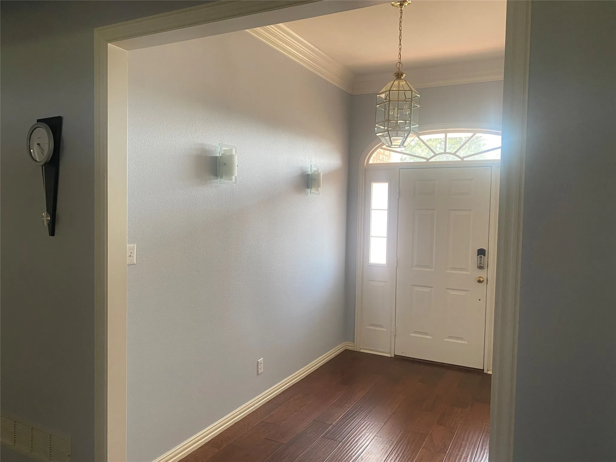 Entryway featuring crown molding, dark wood finished floors, and a chandelier