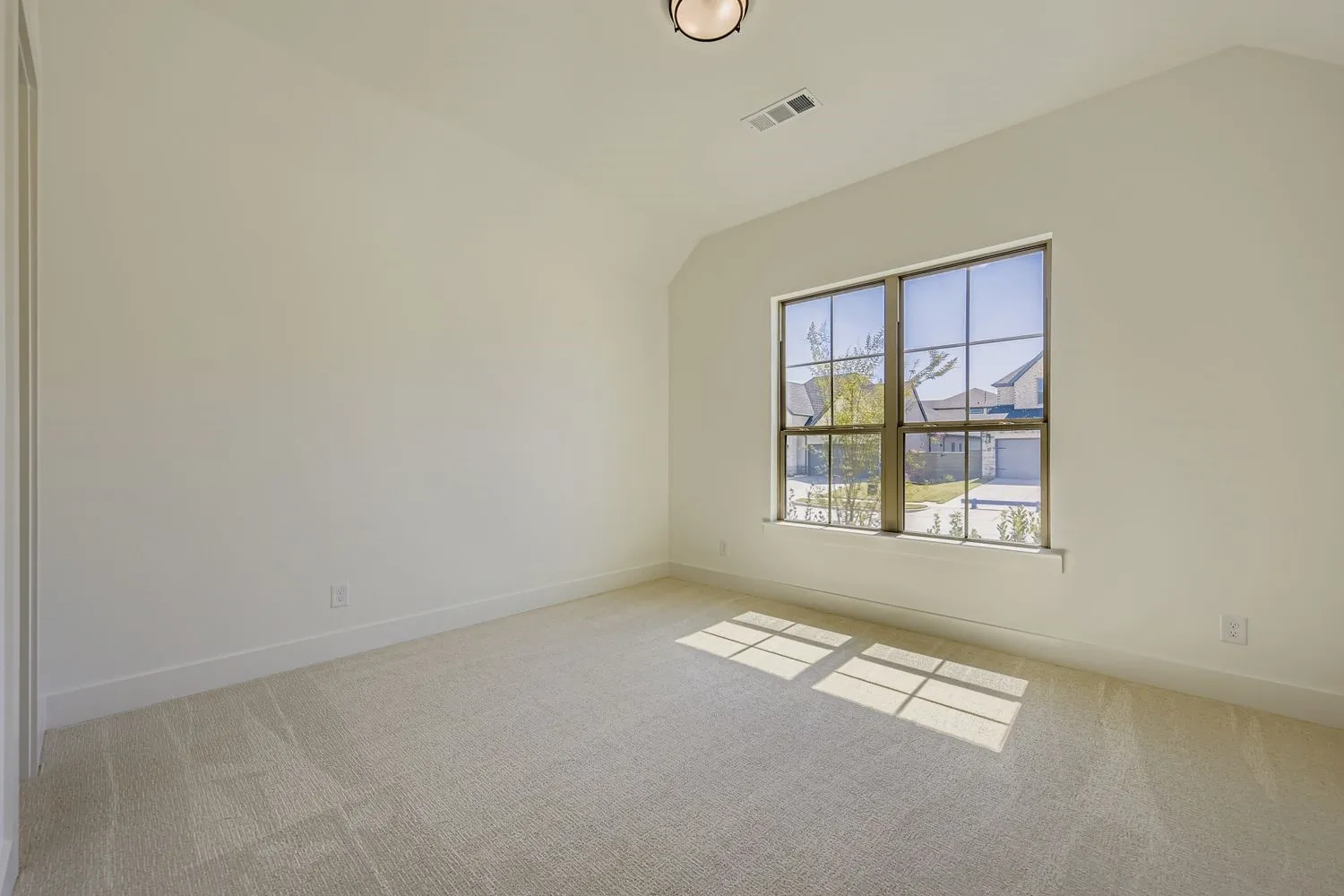 Spare room with vaulted ceiling and light carpet