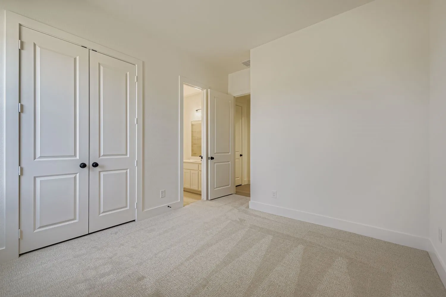 Unfurnished bedroom with carpet floors, ensuite bathroom, and a closet