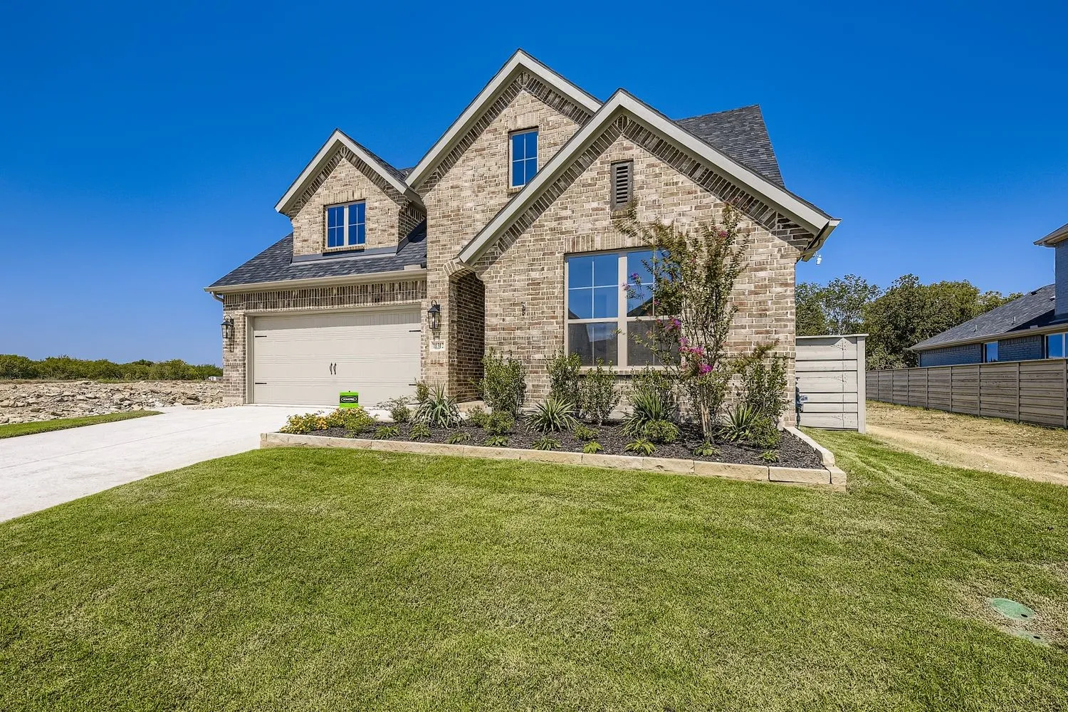 View of front of property with concrete driveway, brick siding, a shingled roof, and an attached garage
