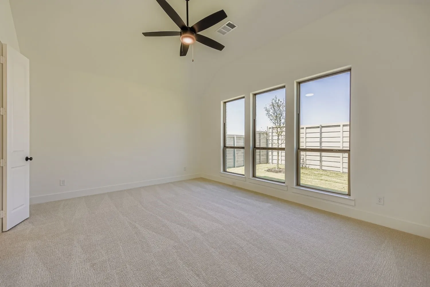 Unfurnished room with light carpet, a ceiling fan, and high vaulted ceiling