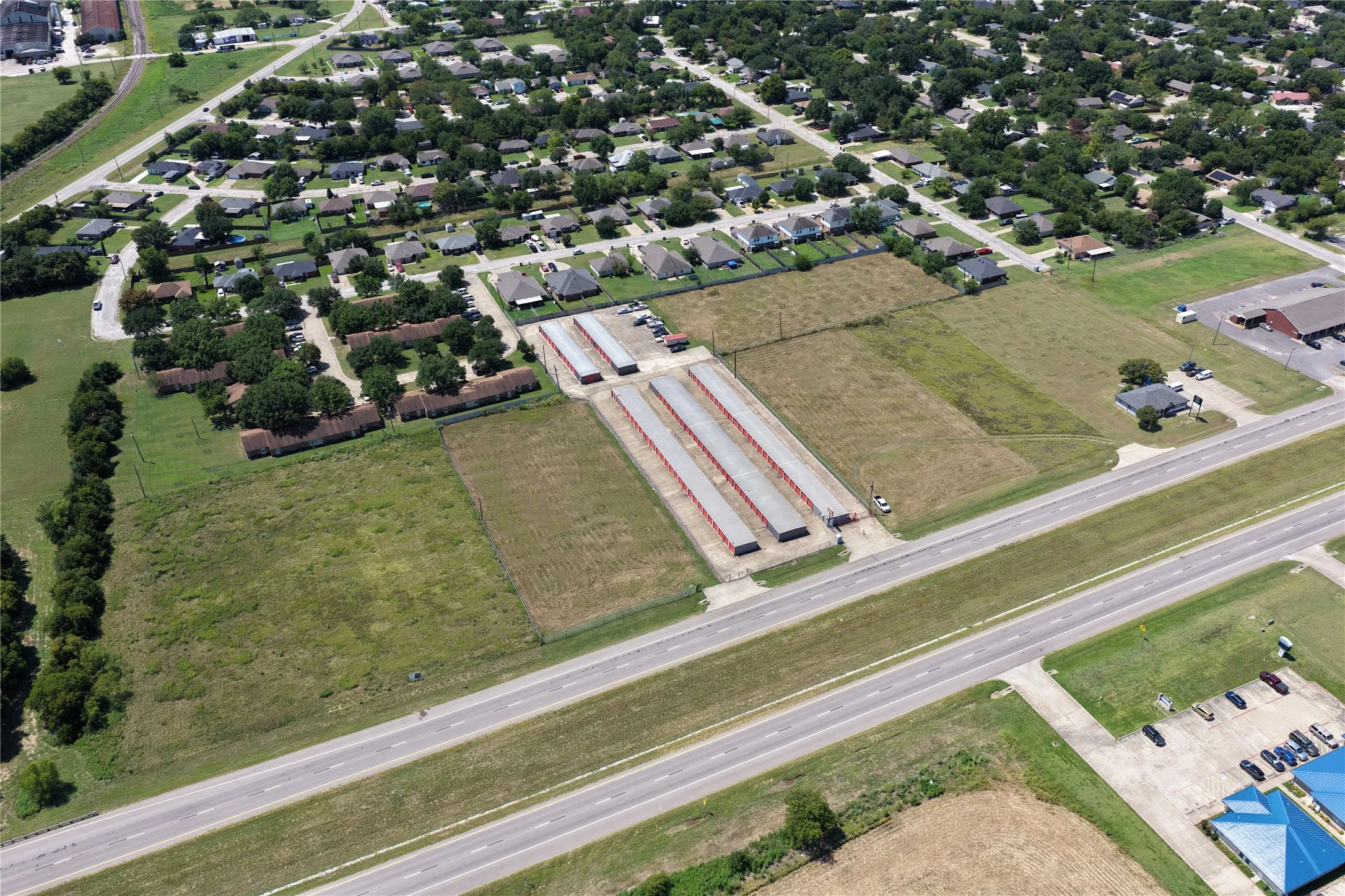Aerial view of property and surrounding area featuring nearby suburban area