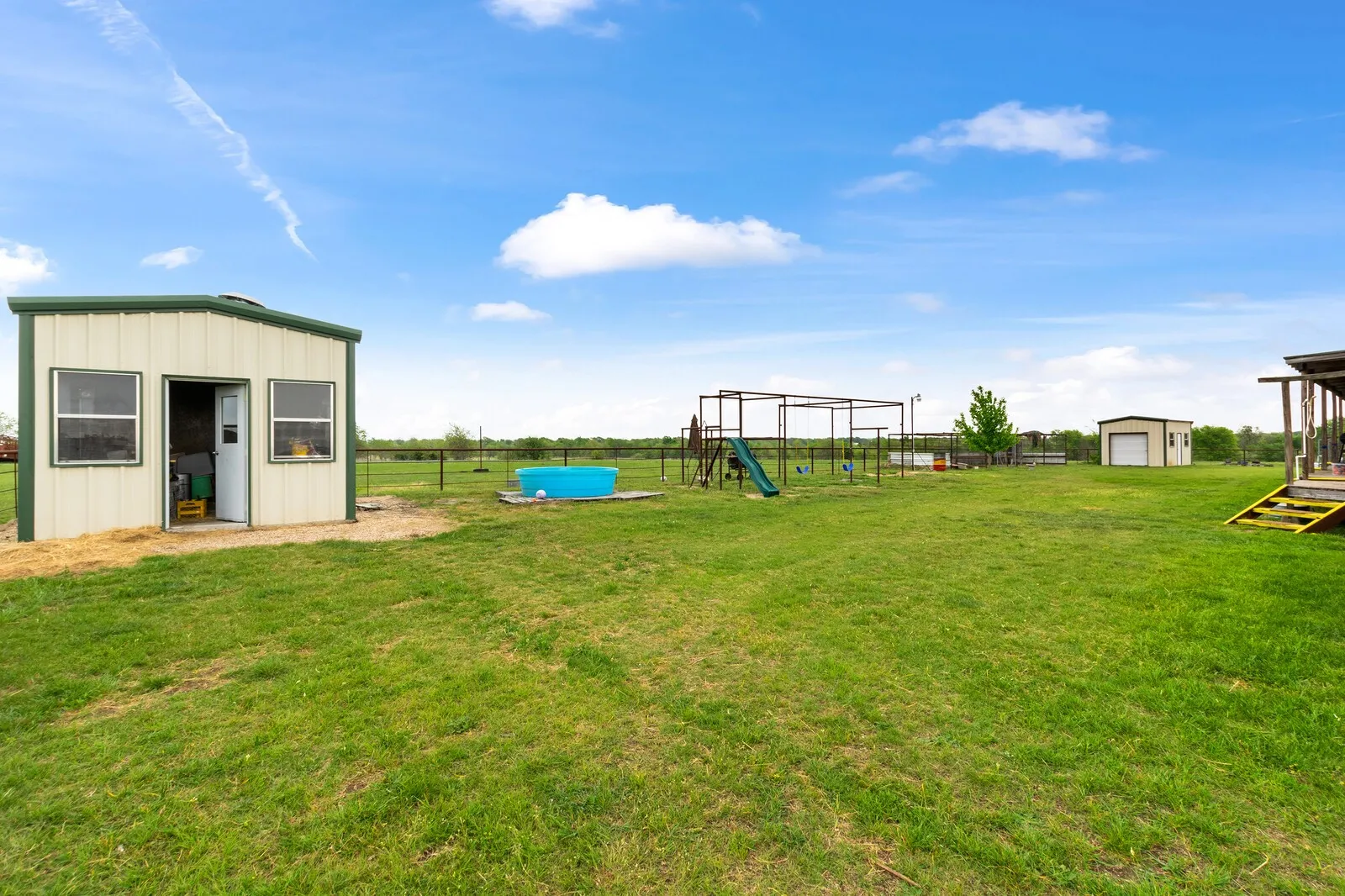 View of yard with a playground and a storage shed