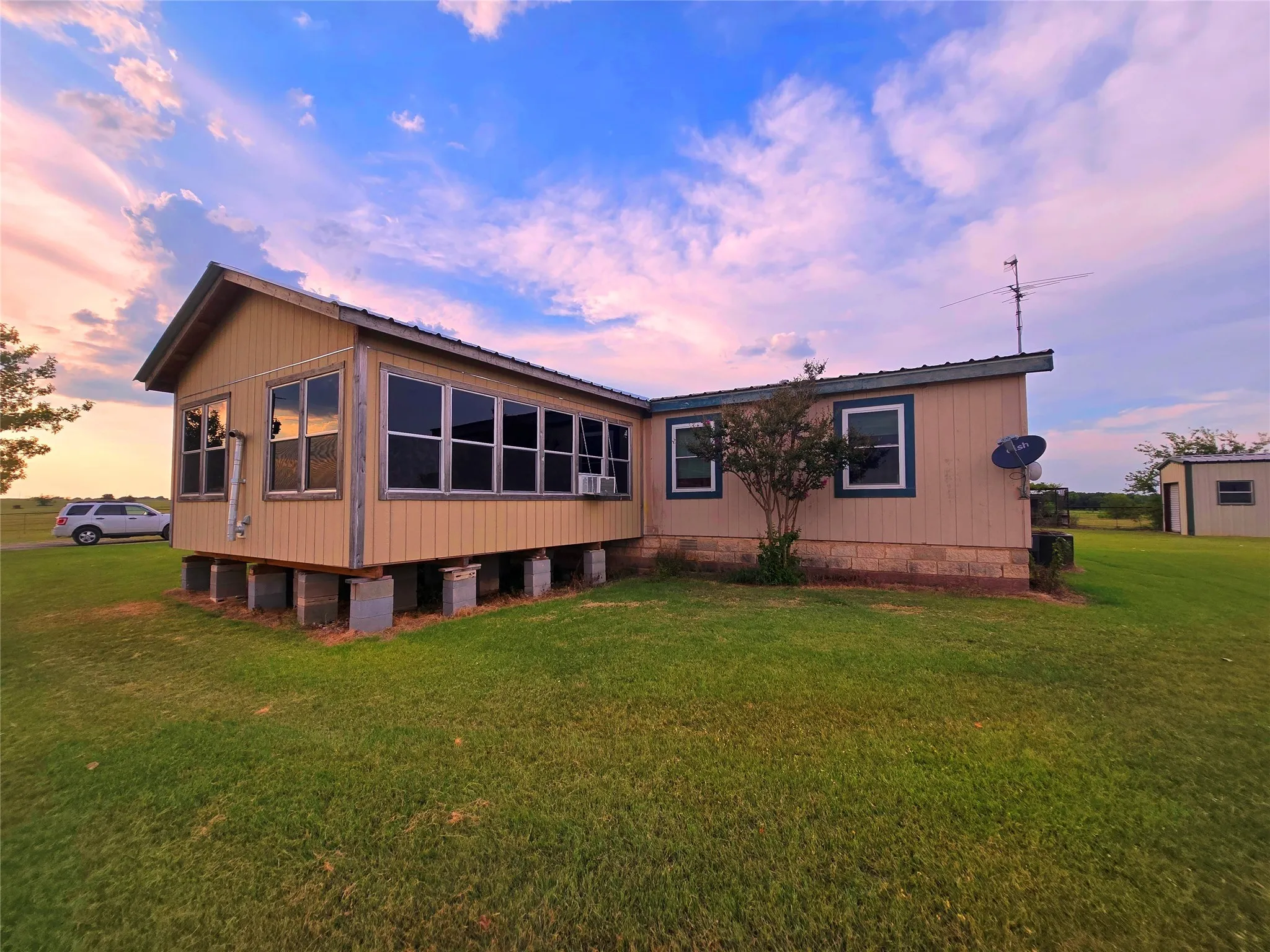Rear view of house featuring a lawn, a metal roof, and crawl space
