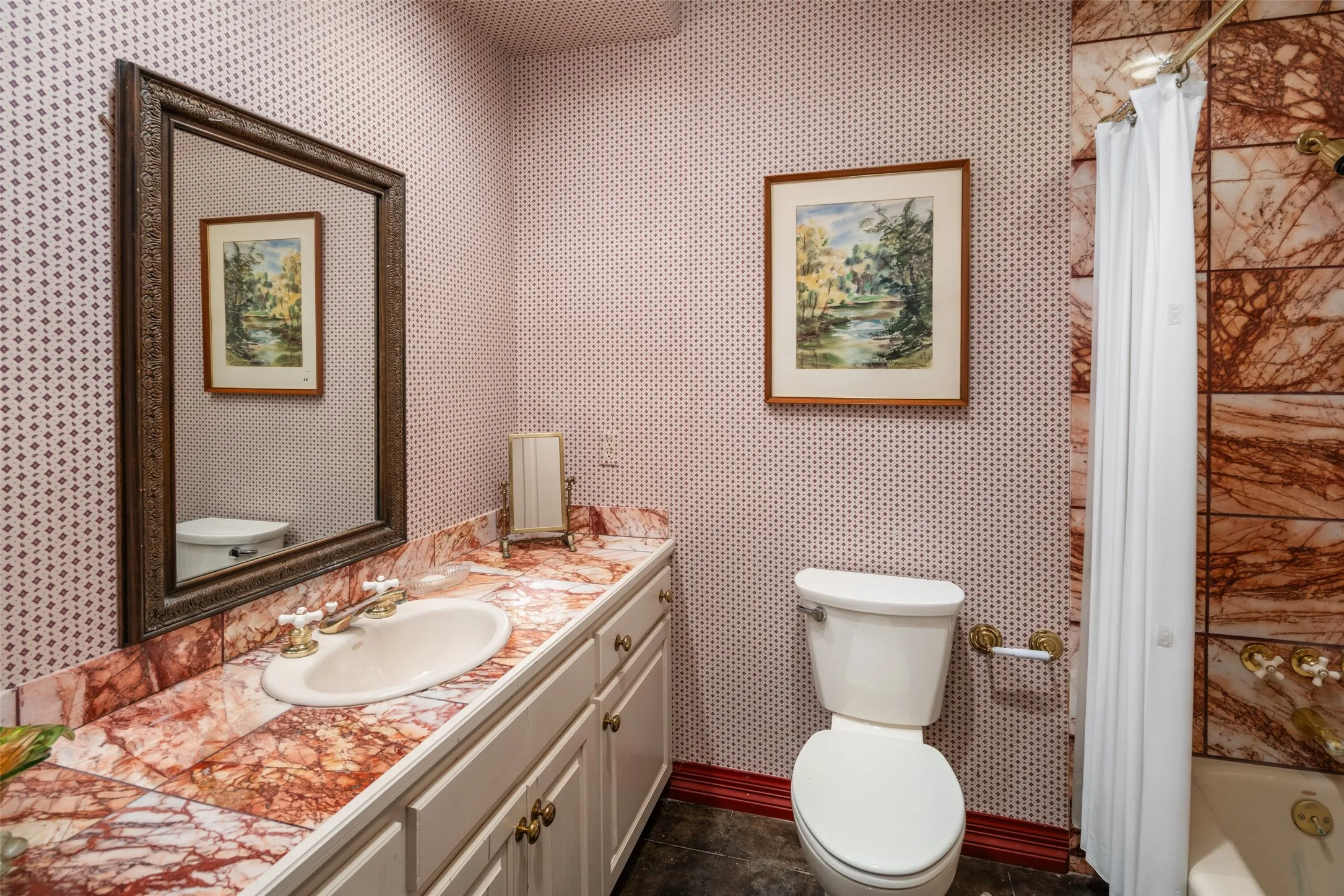 Ensuite bath with beautiful marble tile and wallpaper located on the ground level.