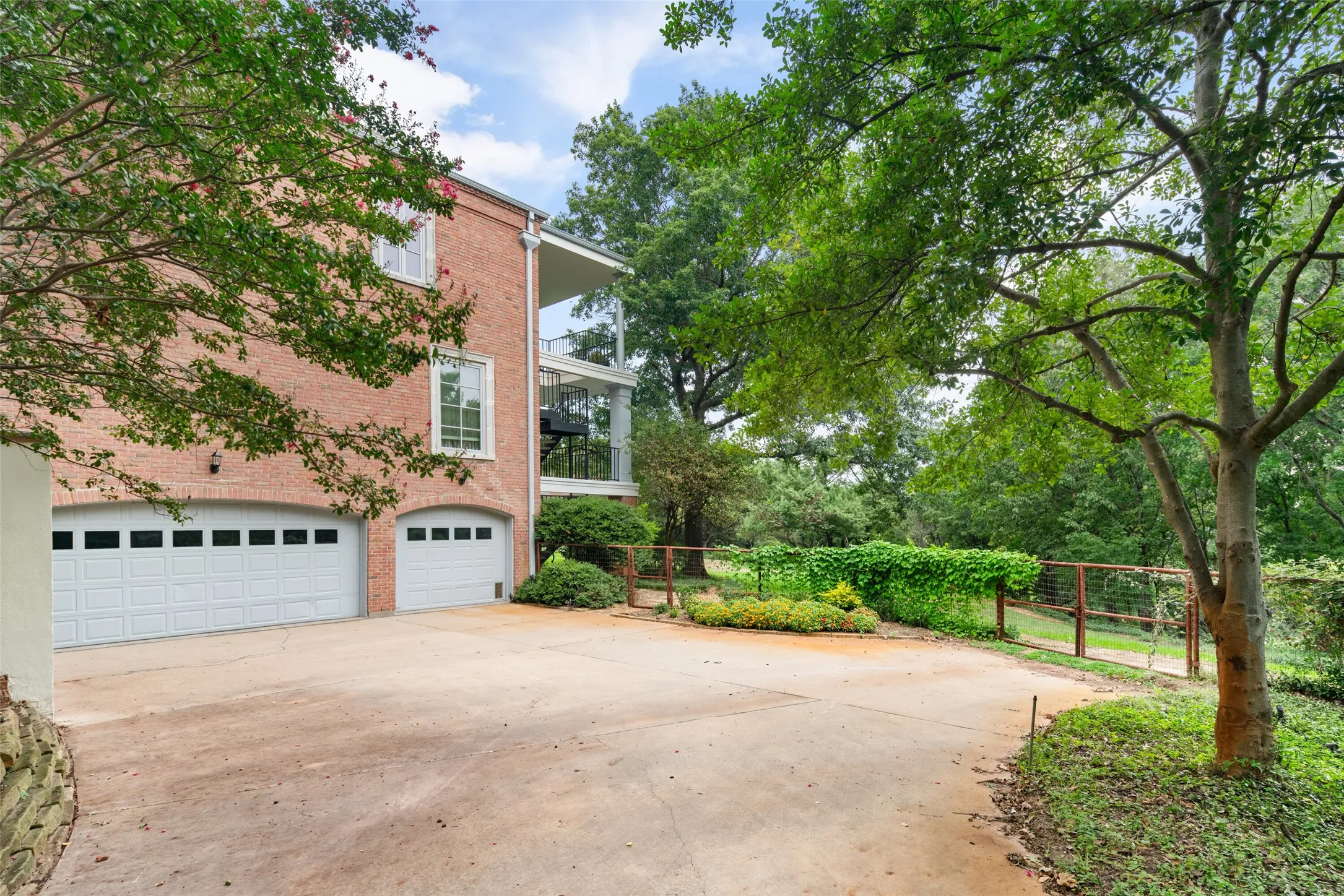 View of property exterior with an attached 4 car garage and storage area.