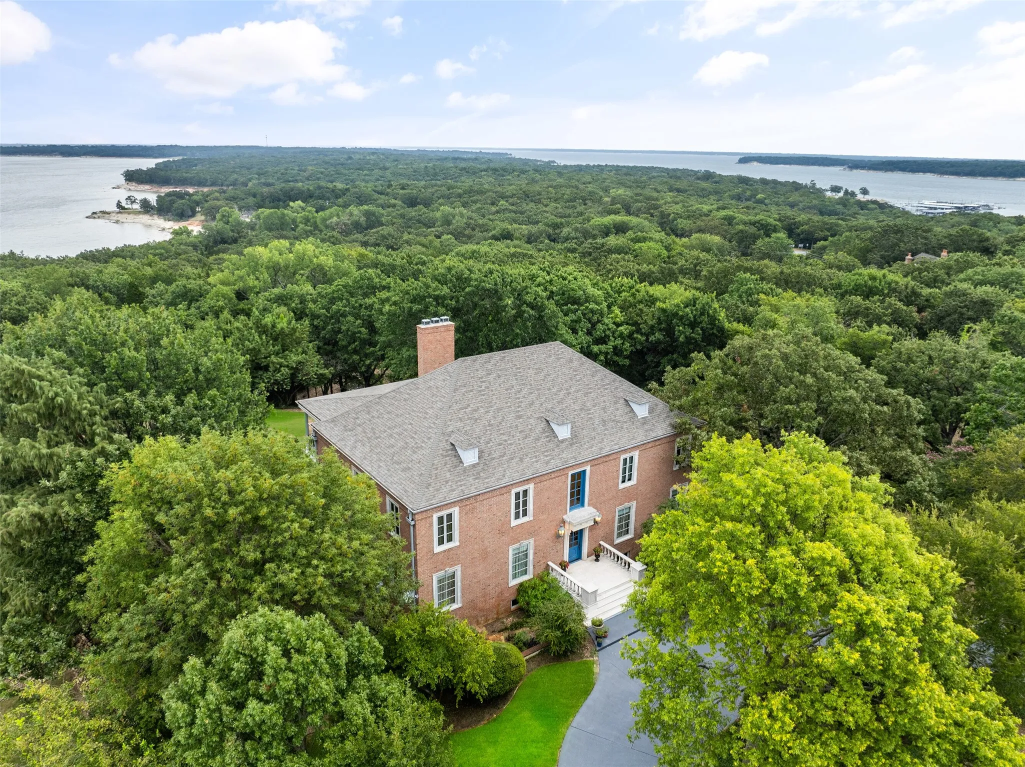 View from above of property with a forest and a large body of water