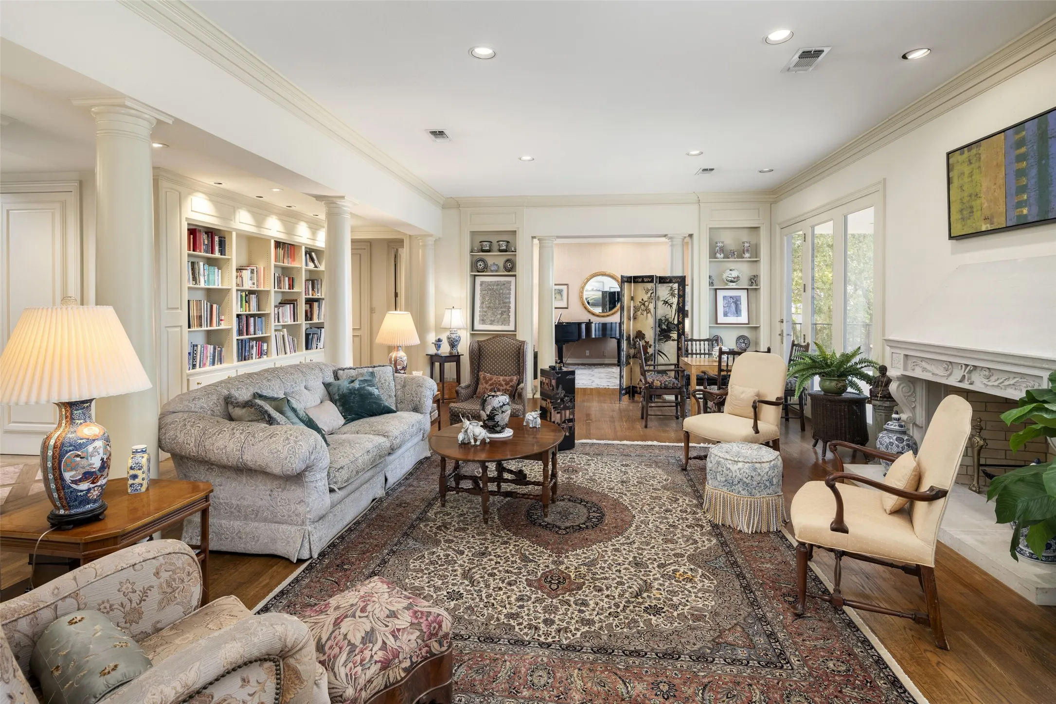 Second Level living room with crown molding, a fireplace, recessed lighting, built in shelves, and wood finished floors with a private balcony.