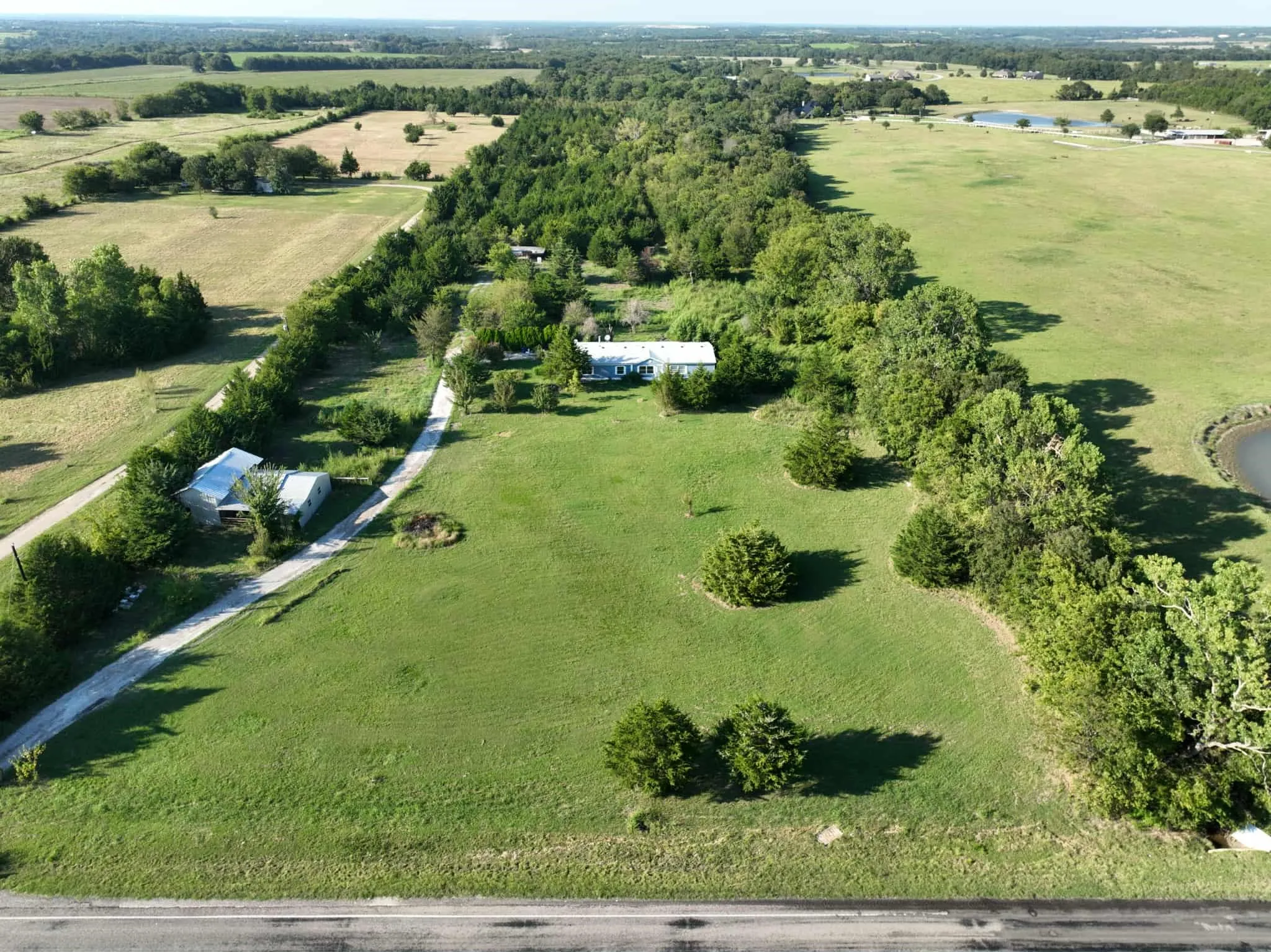 Aerial view of property and surrounding area with rural landscape and a nearby body of water