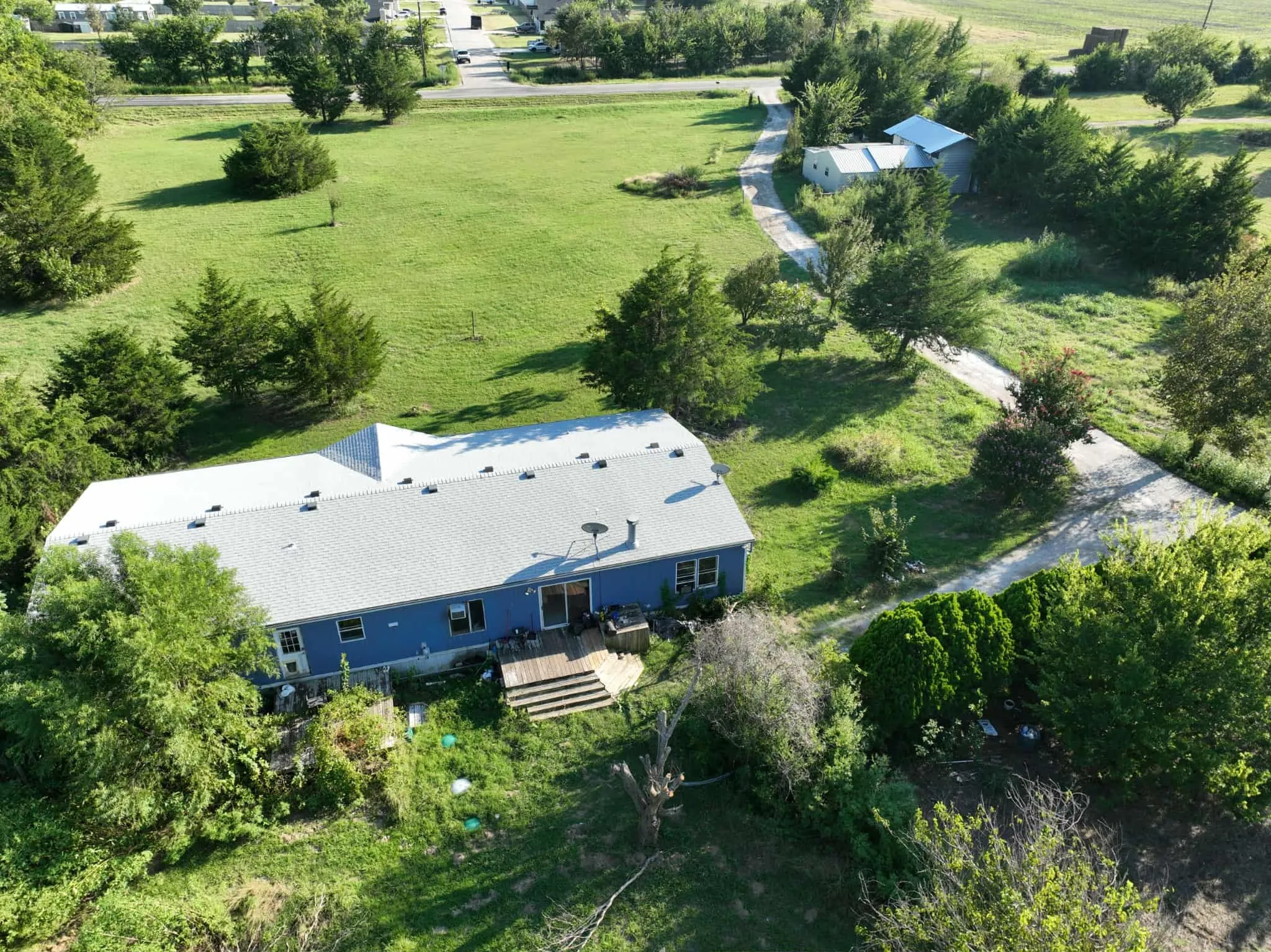 Aerial view of property's location featuring a tree filled landscape