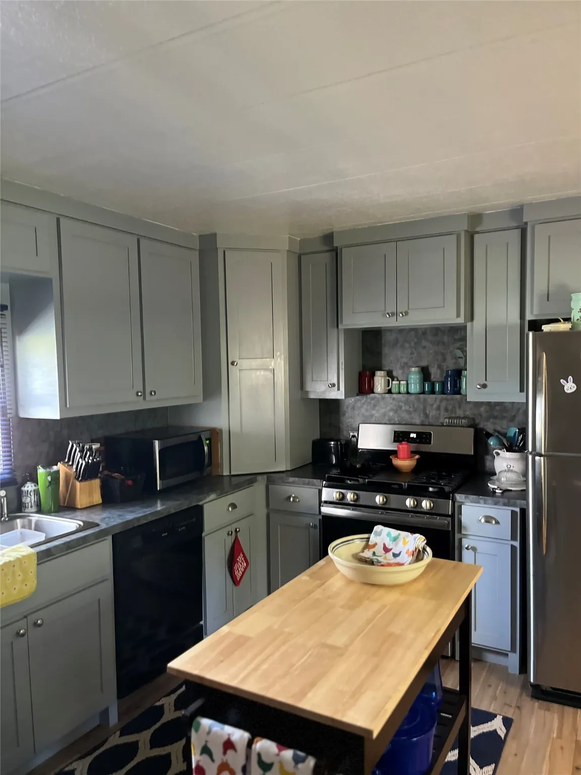 Kitchen with dark countertops, stainless steel appliances, and gray cabinets