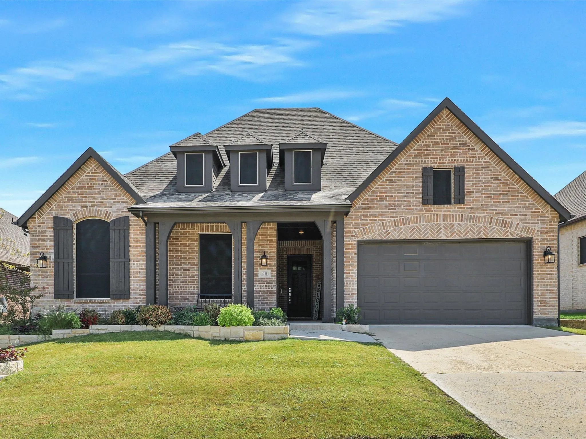 This stunning brick-front home with charming dormer windows and arched entryway is beautifully landscaped and move-in ready. Enjoy curb appeal that stands out in a desirable neighborhood with mature surroundings and well-maintained yards.
