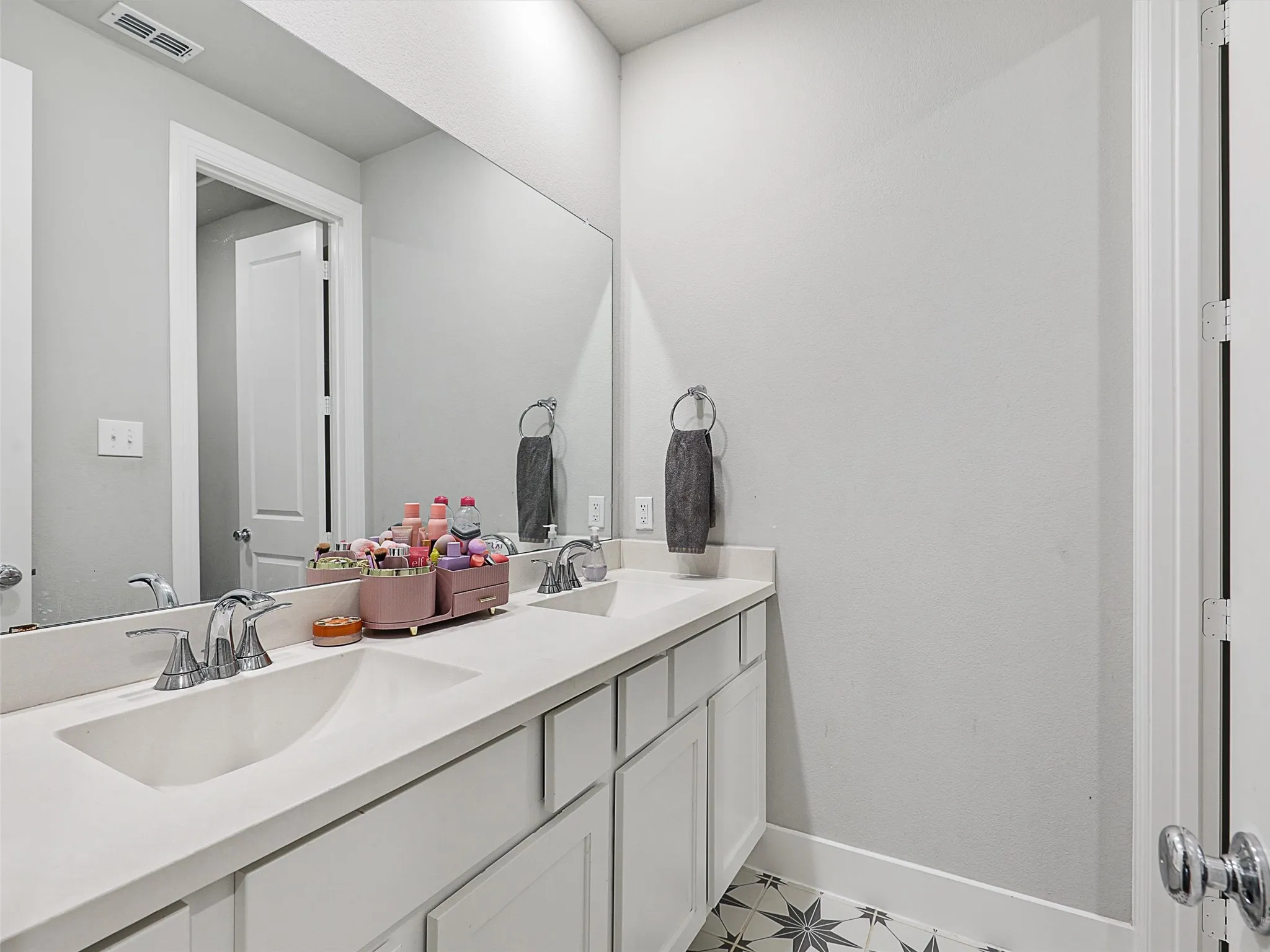 Full guest bath with modern finishes and easy access from the hallway—ideal for visitors or everyday use. With custom tile work, dual vanities and seperate shower area.