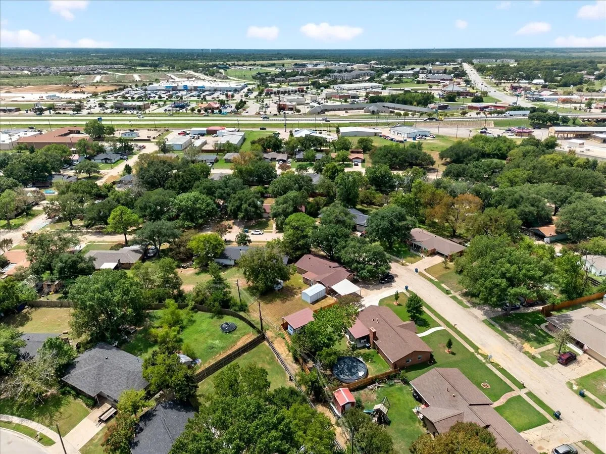 Aerial view of property and surrounding area with nearby suburban area