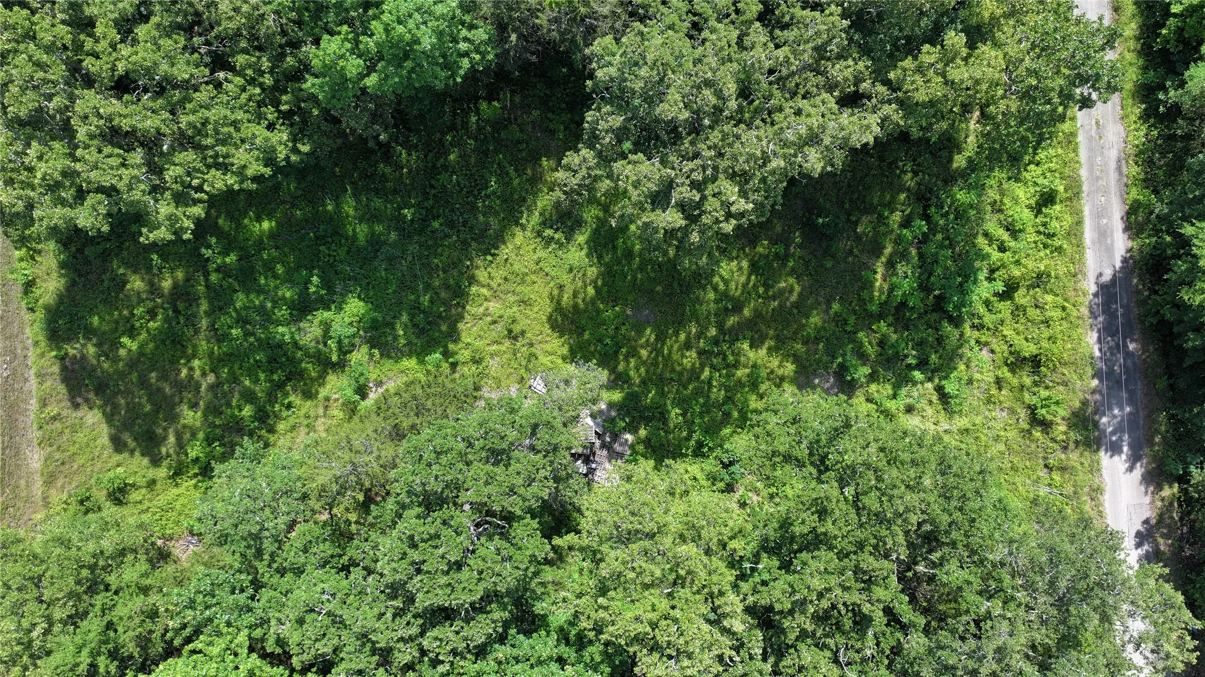 Aerial overview of property's location with a heavily wooded area