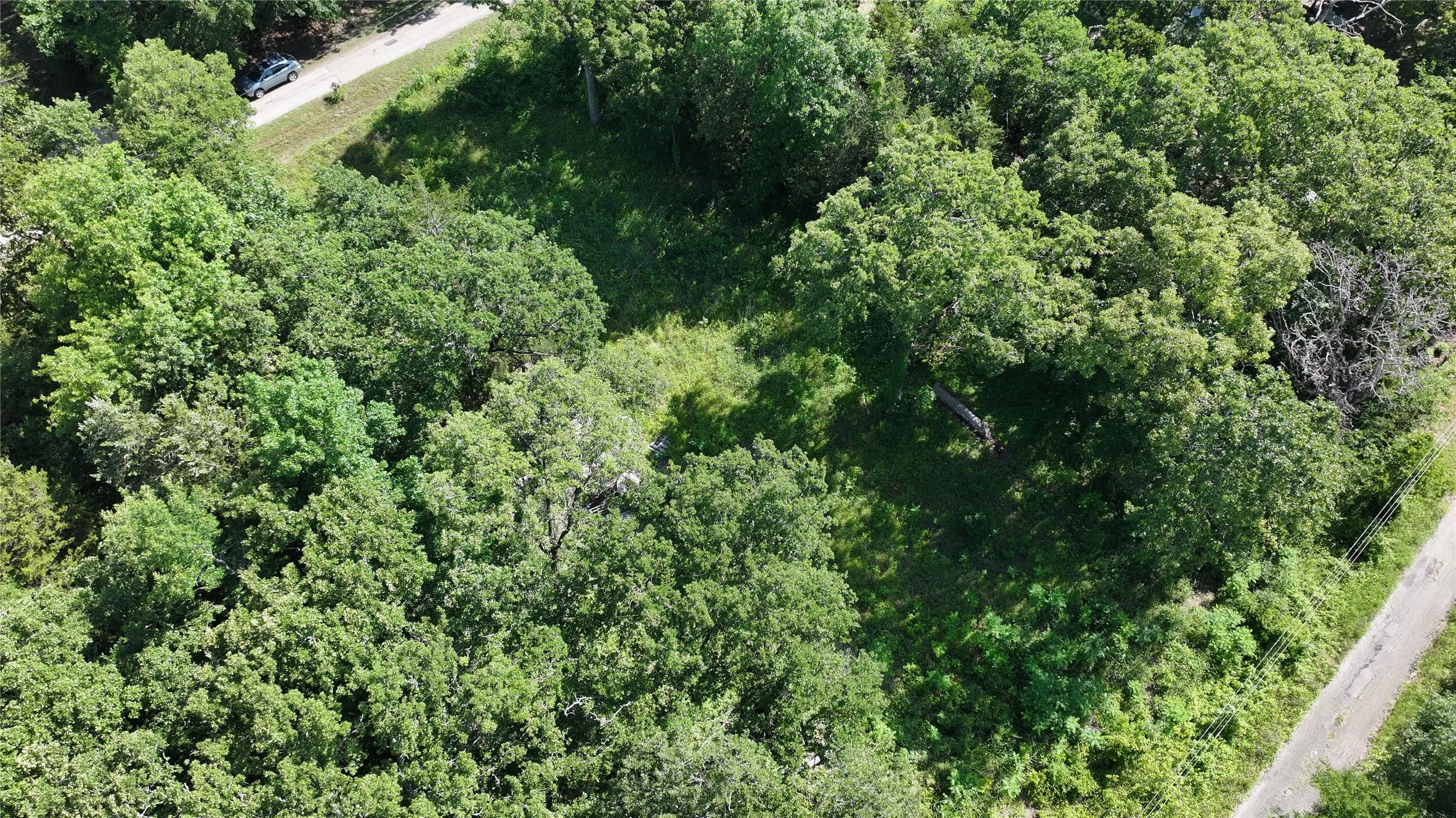 Aerial view of property's location with a heavily wooded area