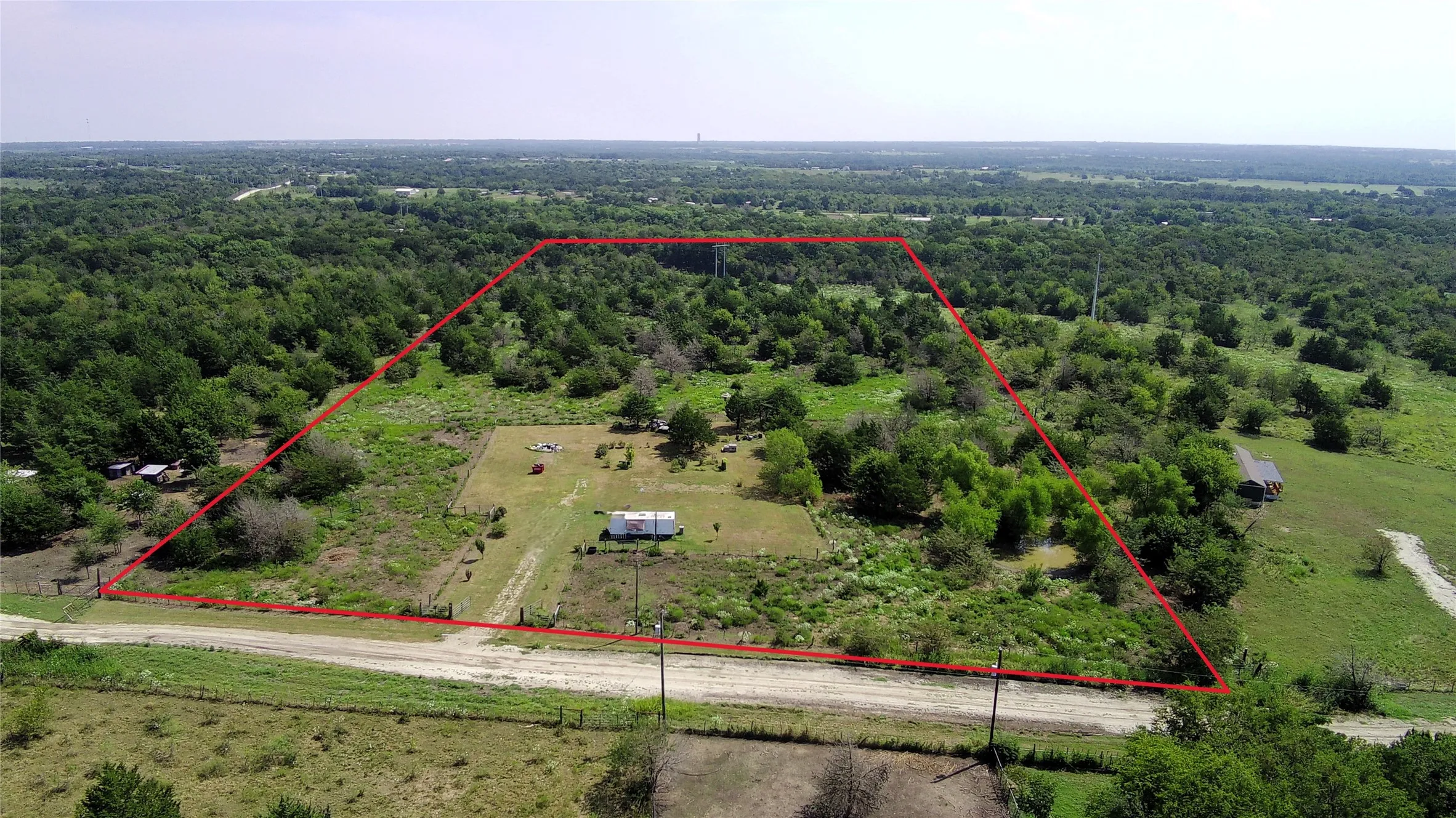 Aerial view of sparsely populated area featuring property parcel outlined