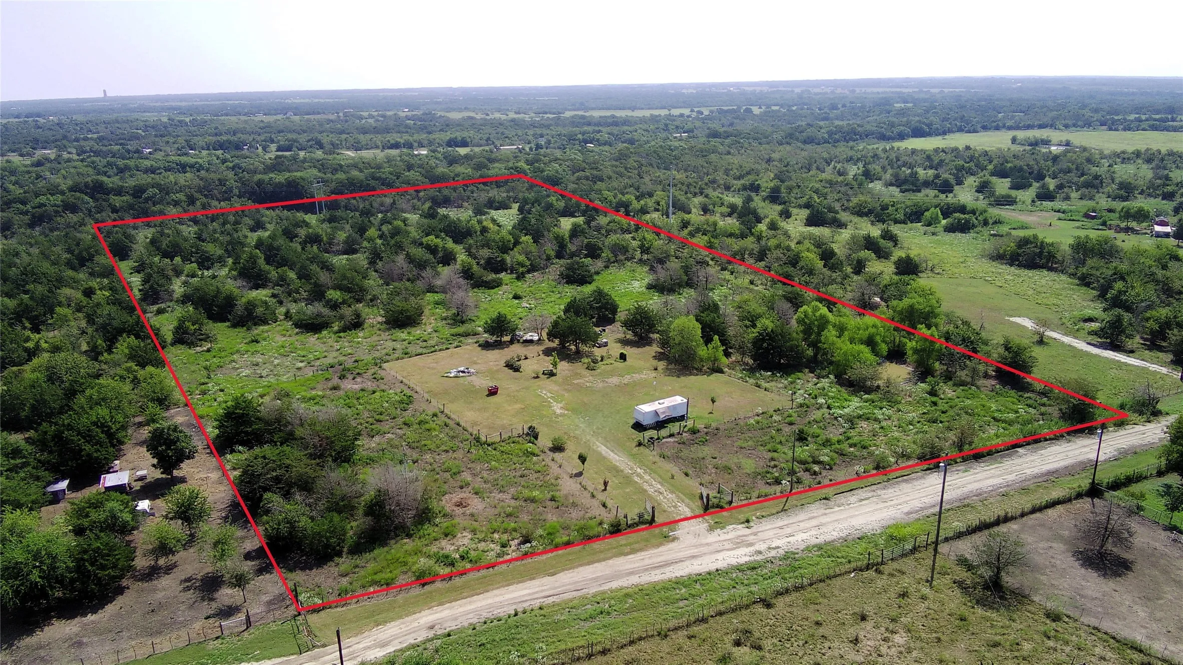 Aerial view of sparsely populated area featuring property boundaries highlighted