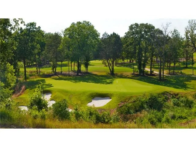 Surrounding community featuring view of wooded area and view of golf course