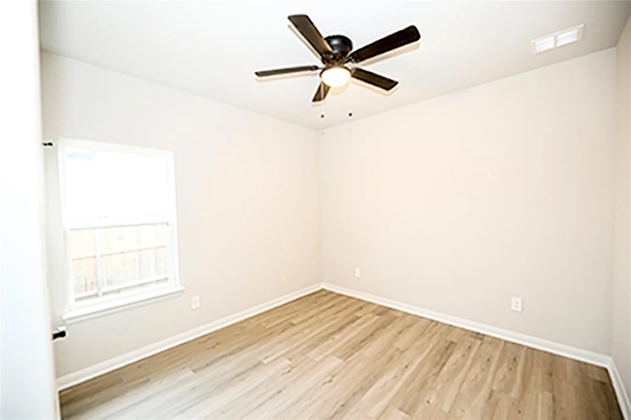 Unfurnished room with ceiling fan and light wood-type flooring