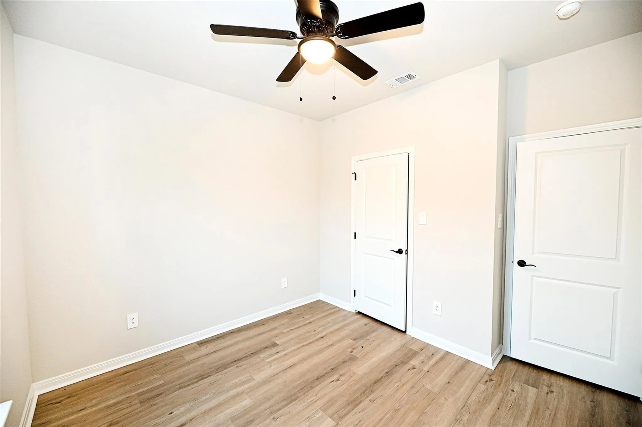 Unfurnished bedroom featuring ceiling fan and light hardwood / wood-style floors