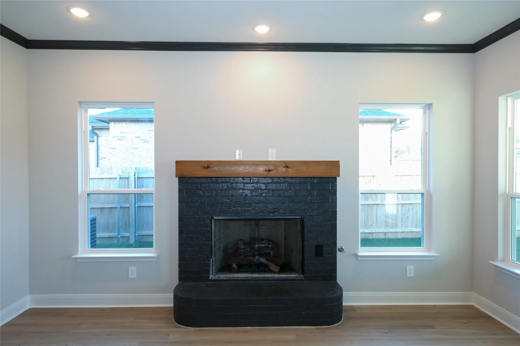 Details with wood-type flooring, crown molding, and a brick fireplace