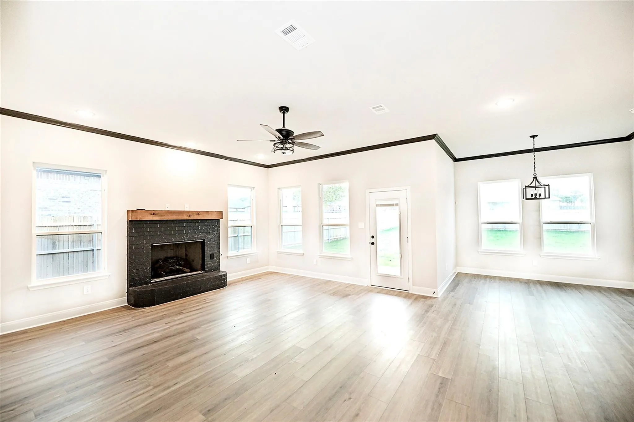 Unfurnished living room with ornamental molding, ceiling fan, and light hardwood / wood-style floors