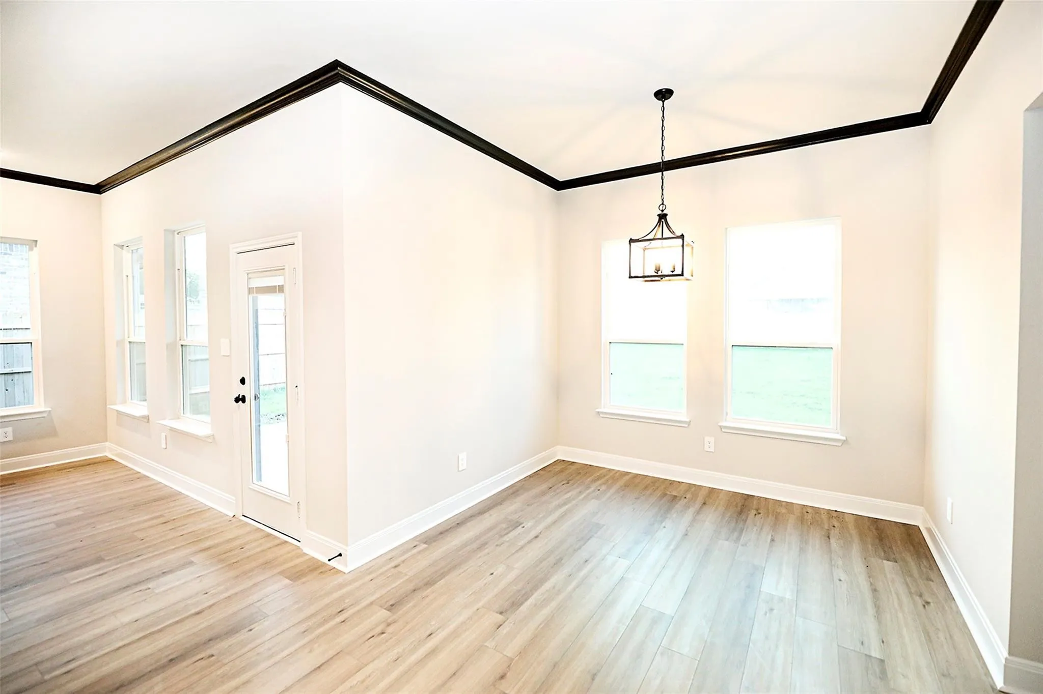 Foyer with light hardwood / wood-style flooring, a healthy amount of sunlight, and crown molding