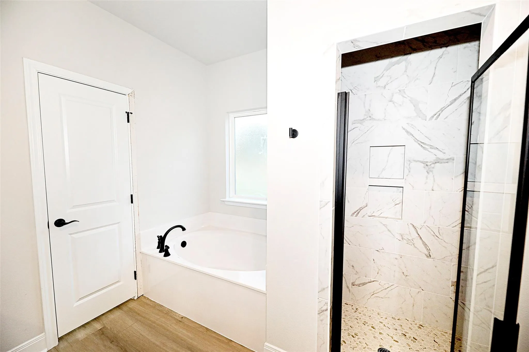 Bathroom with wood-type flooring and independent shower and bath