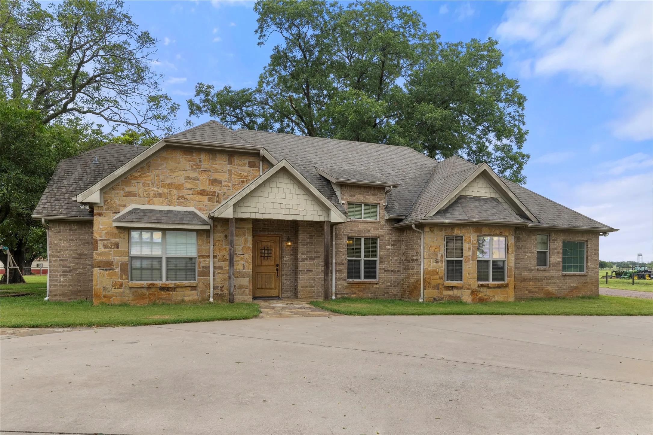 Craftsman house with roof with shingles, a front lawn, and brick siding