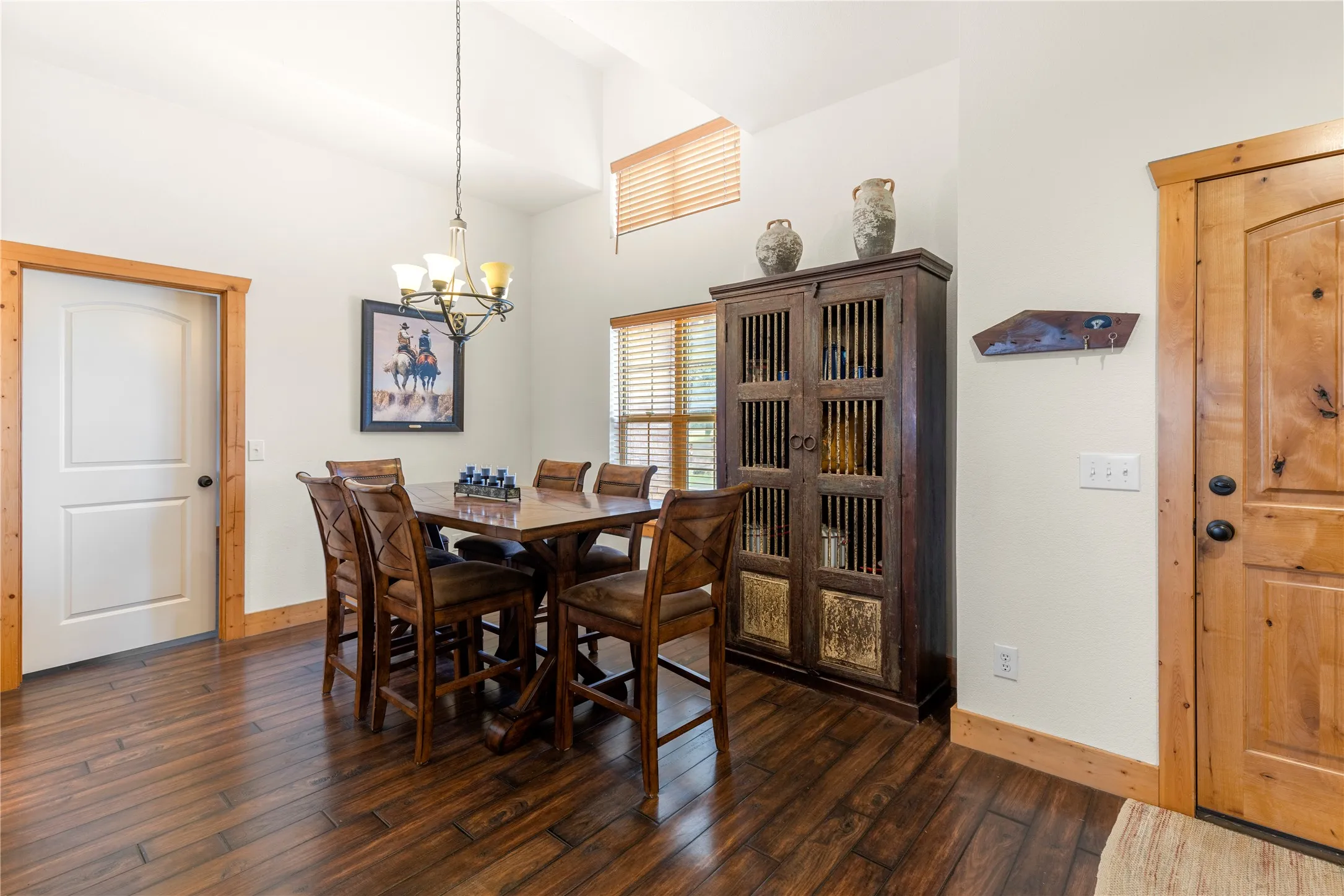Dining space with dark wood-style flooring and a chandelier