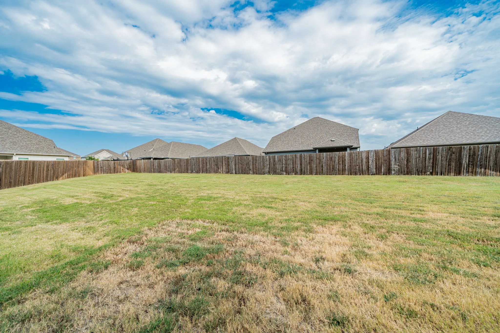 Fenced backyard featuring a residential view