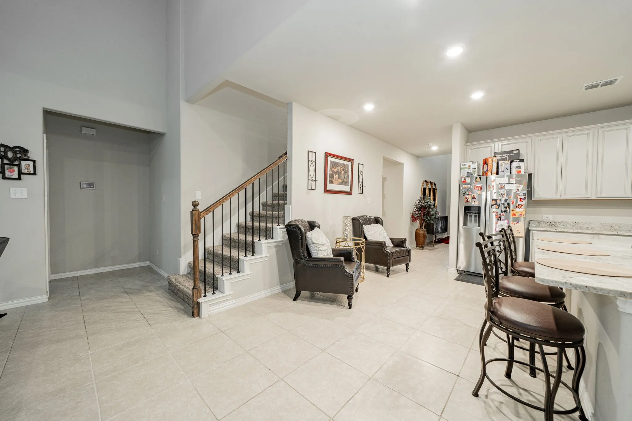Dining space with light tile patterned floors, recessed lighting, and stairway