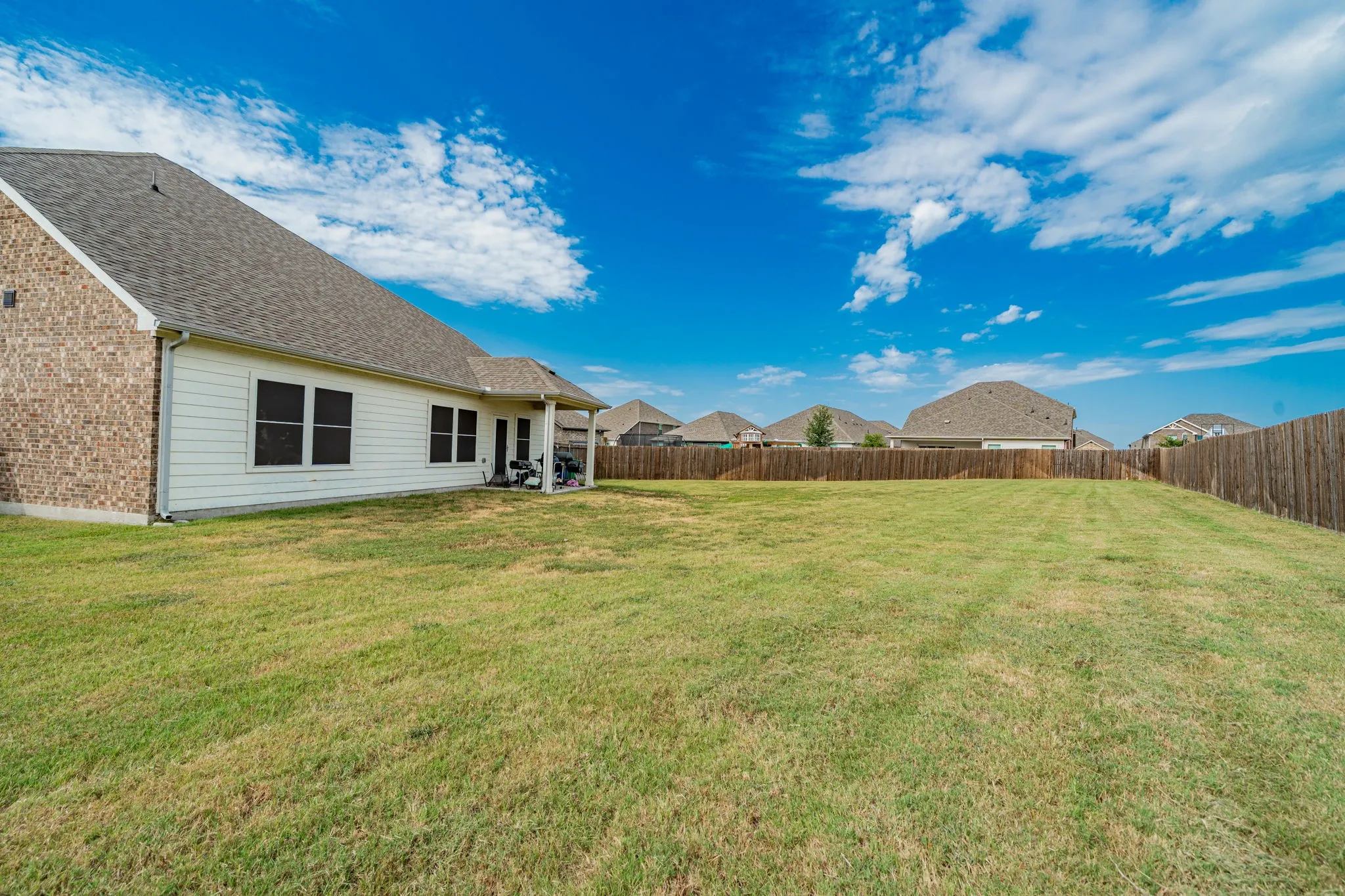 Fenced backyard with a patio area and a residential view
