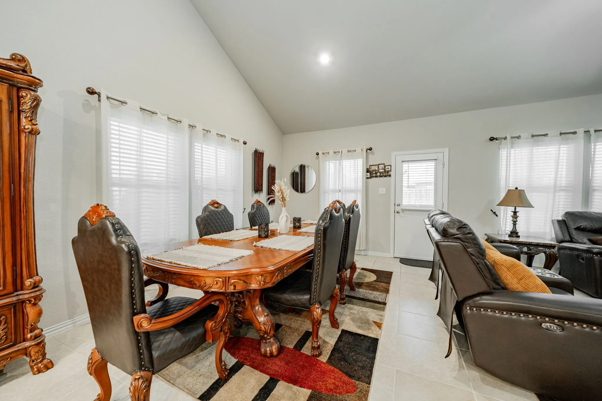 Dining room featuring high vaulted ceiling and light tile patterned floors