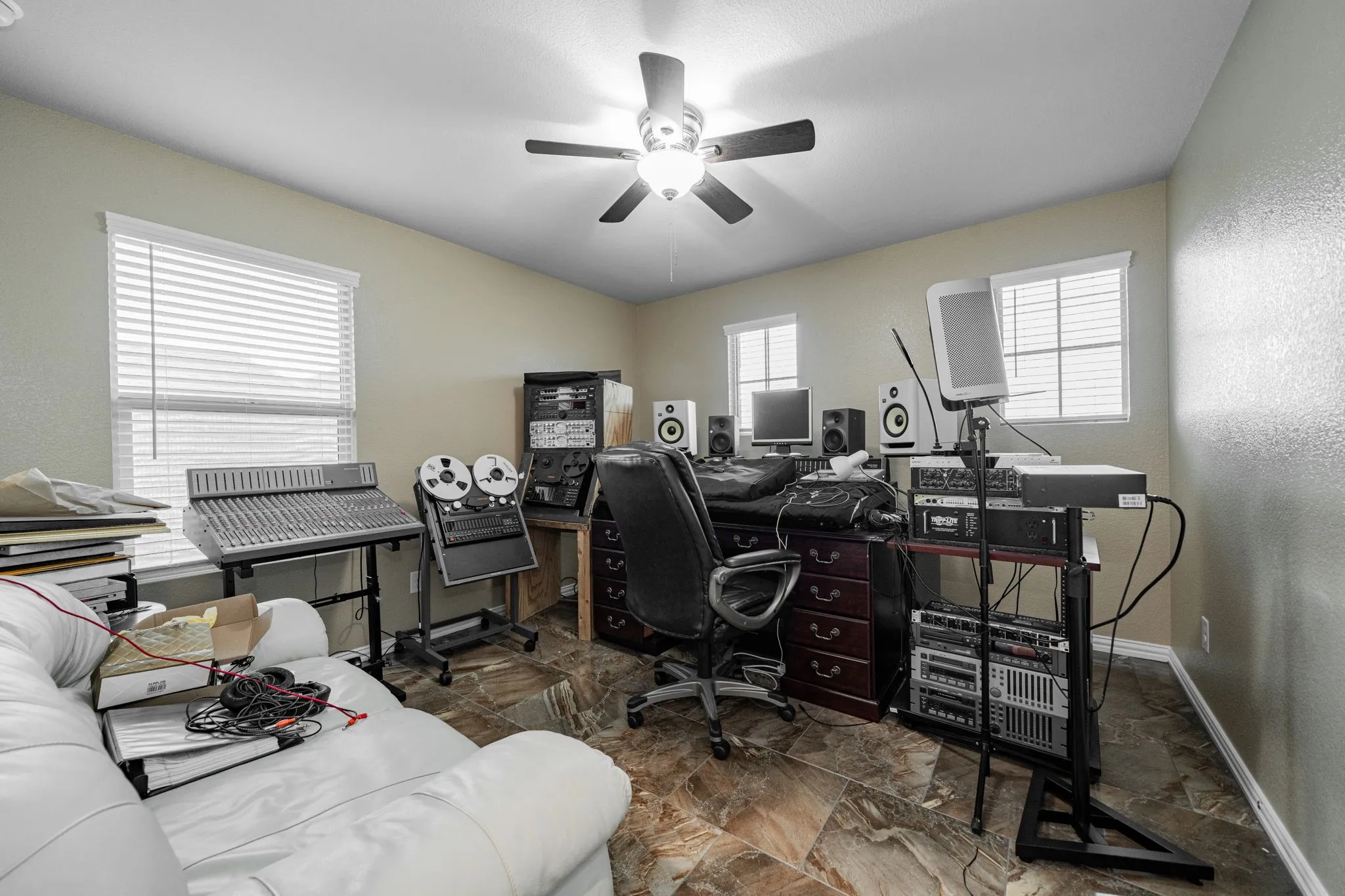 Office featuring dark marble finish flooring and a ceiling fan