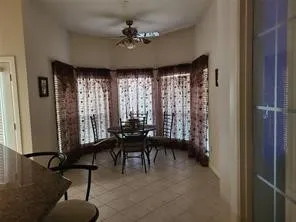 Dining area with a ceiling fan and light tile patterned floors