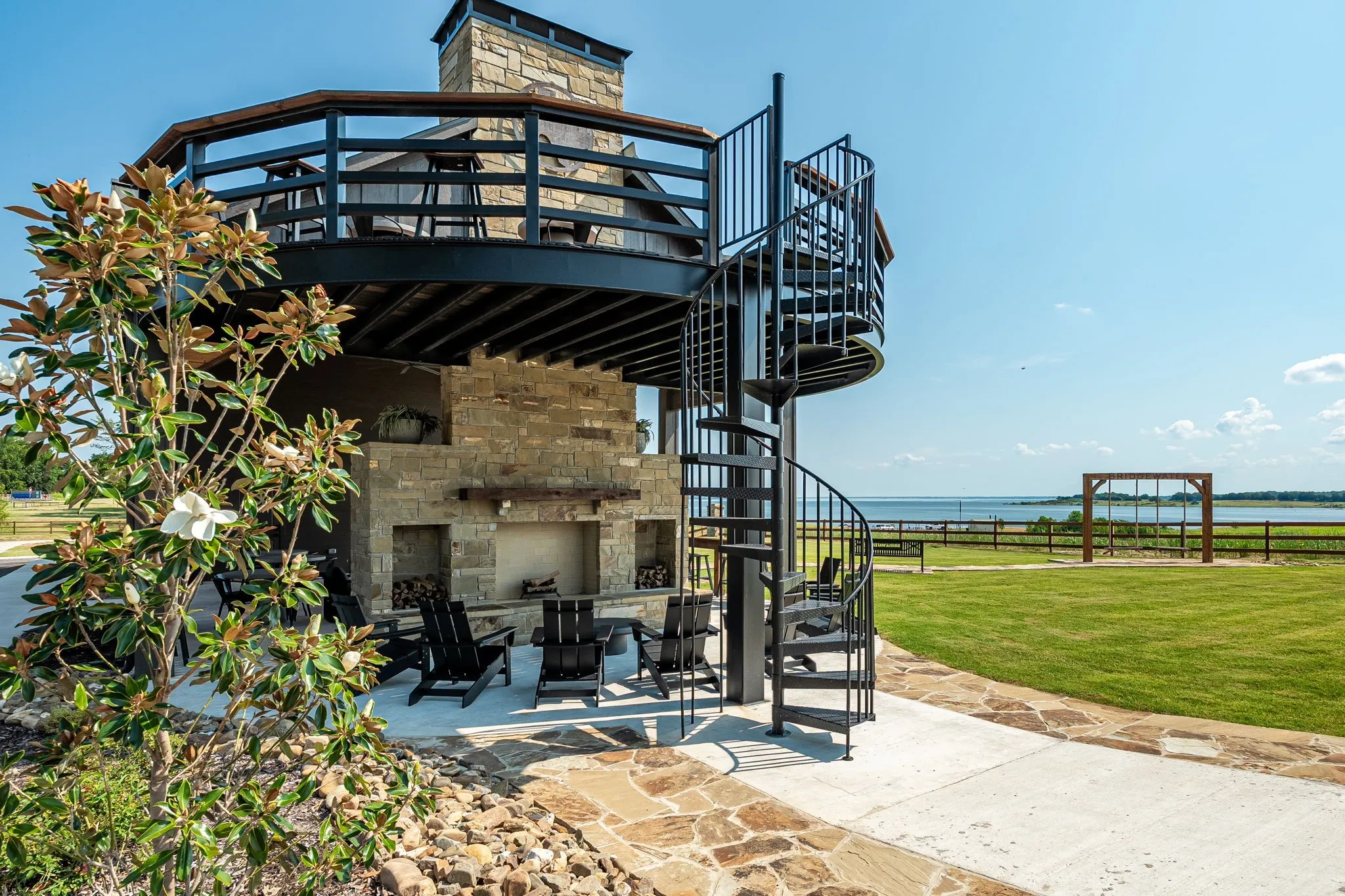 View of patio / terrace with a water view, an outdoor stone fireplace, and stairway