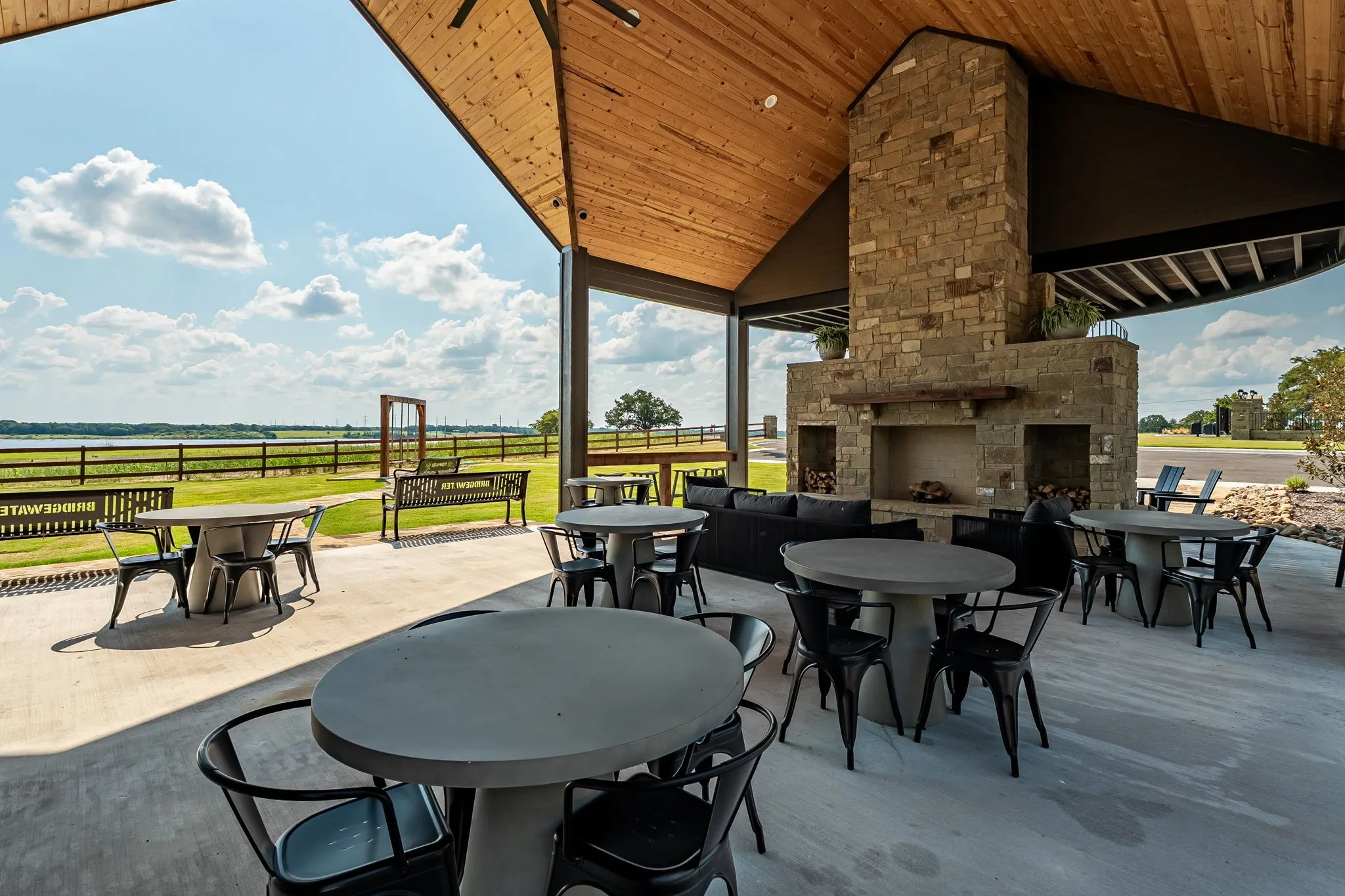 View of patio featuring an outdoor stone fireplace and outdoor dining space at Community Center