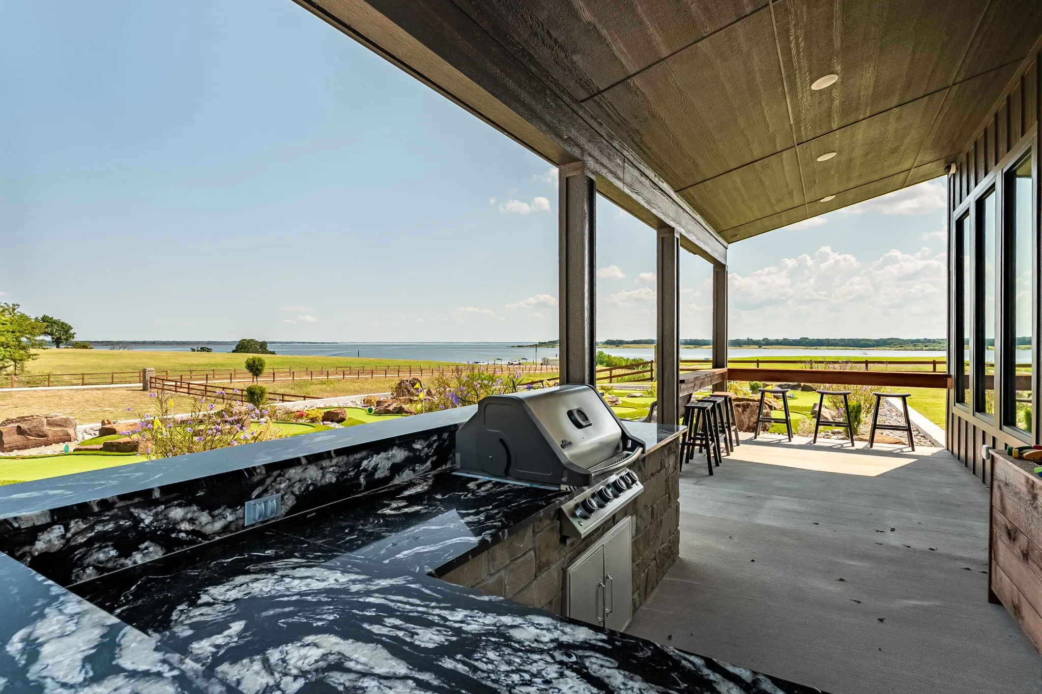 View of patio featuring a water view and exterior kitchen at Community Center