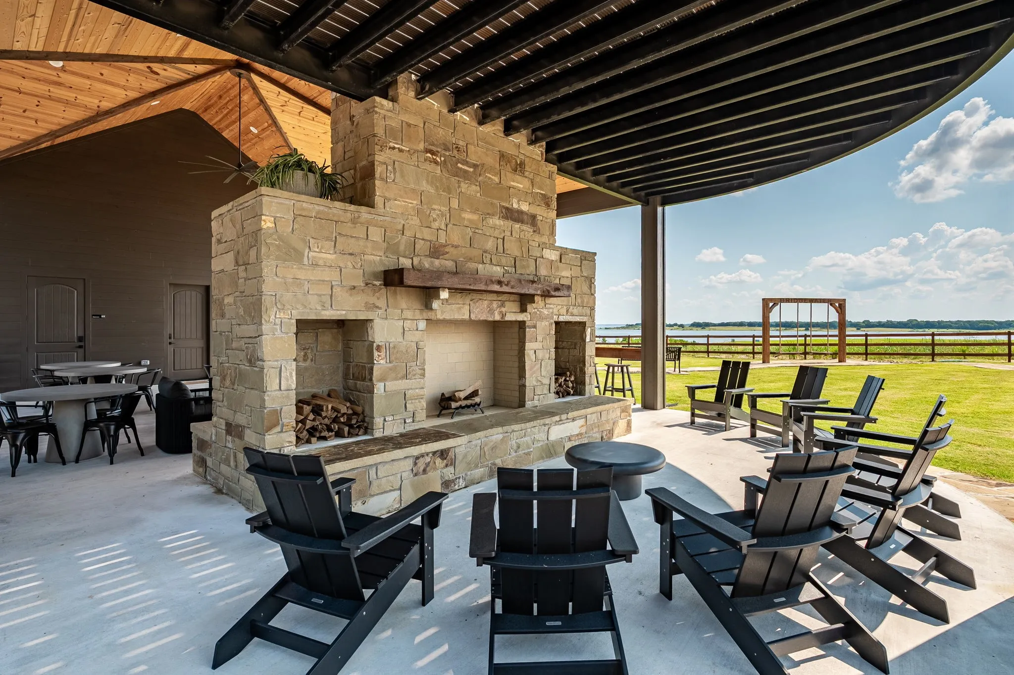 View of patio / terrace with an outdoor stone fireplace and ceiling fan at Community Center