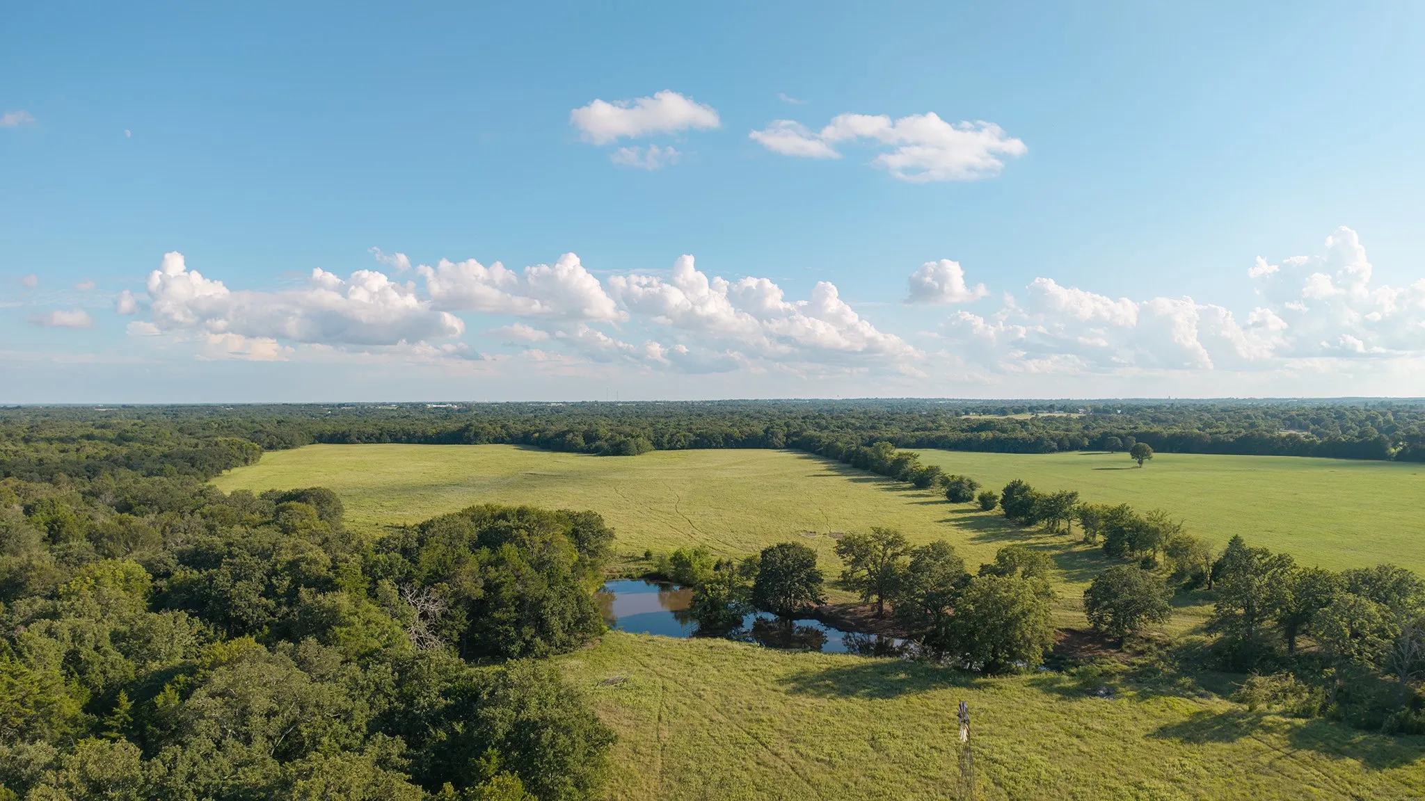 View of rural area with a nearby body of water and a pastoral area
