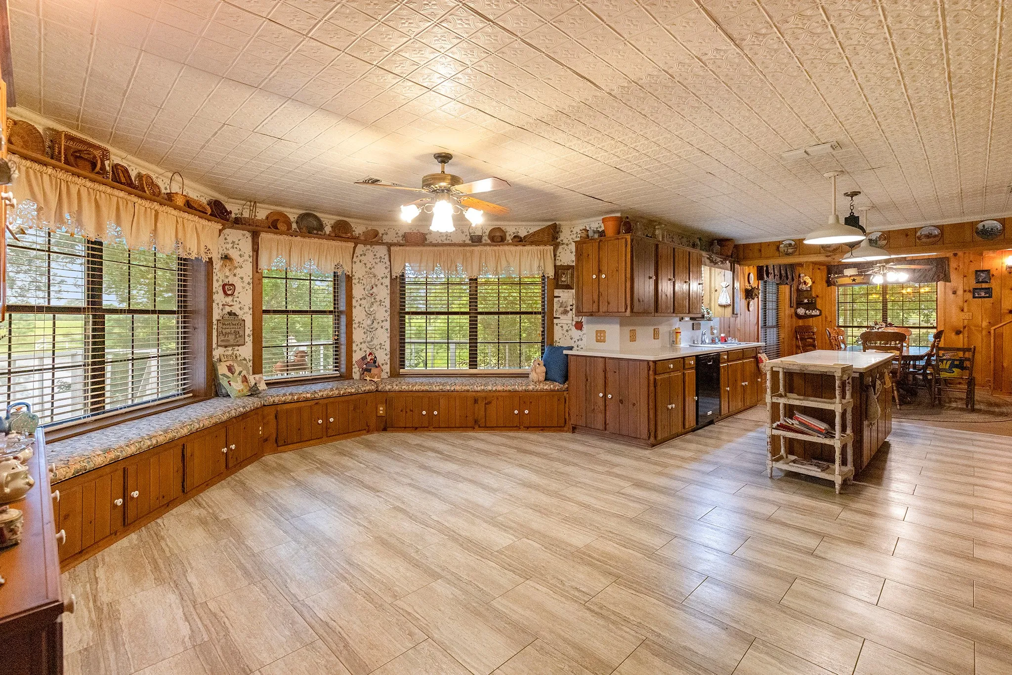 Kitchen with open shelves, light countertops, decorative light fixtures, brown cabinets, and a center island