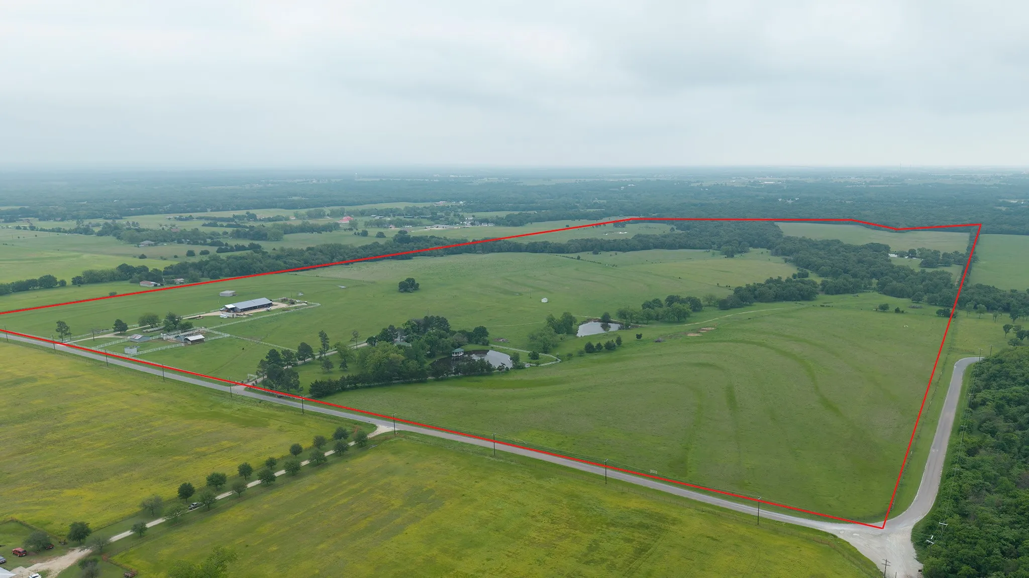 Aerial view of sparsely populated area with property parcel outlined