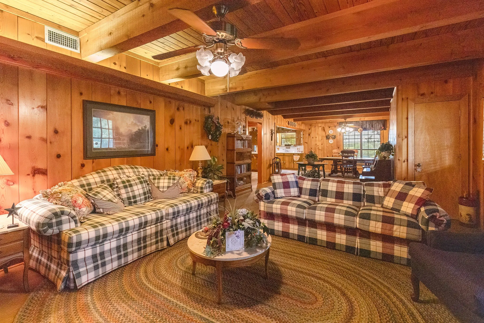 Living room featuring wood walls and beamed ceiling