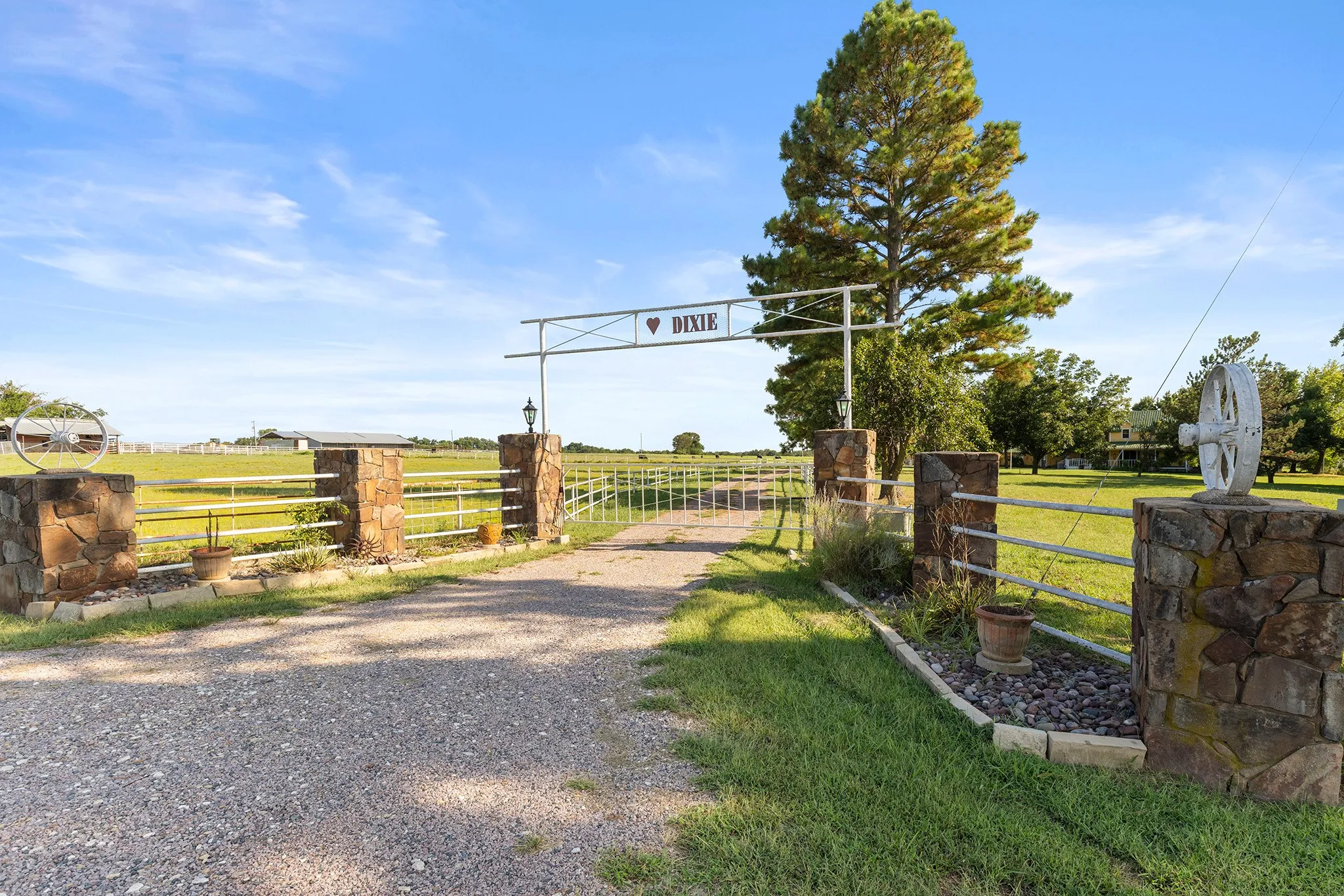 View of dirt / gravel road with a gate, a gated entry, and a rural view